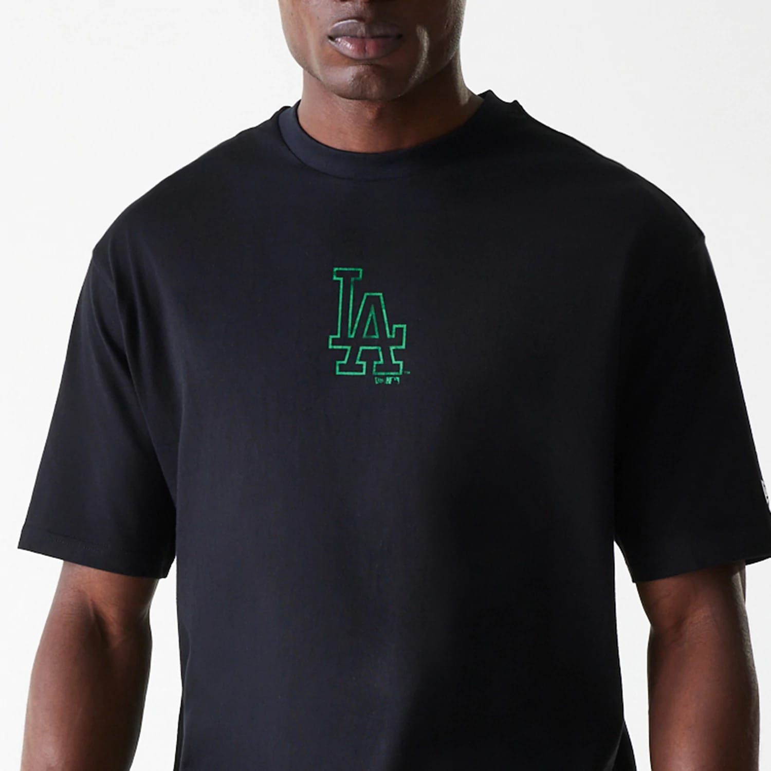 New Era LA Dodgers MLB World Series Black Oversized T-Shirt, front view showing a black T-shirt with a green embroidered LA Dodgers logo centred on the chest, short sleeves, and a round neckline.