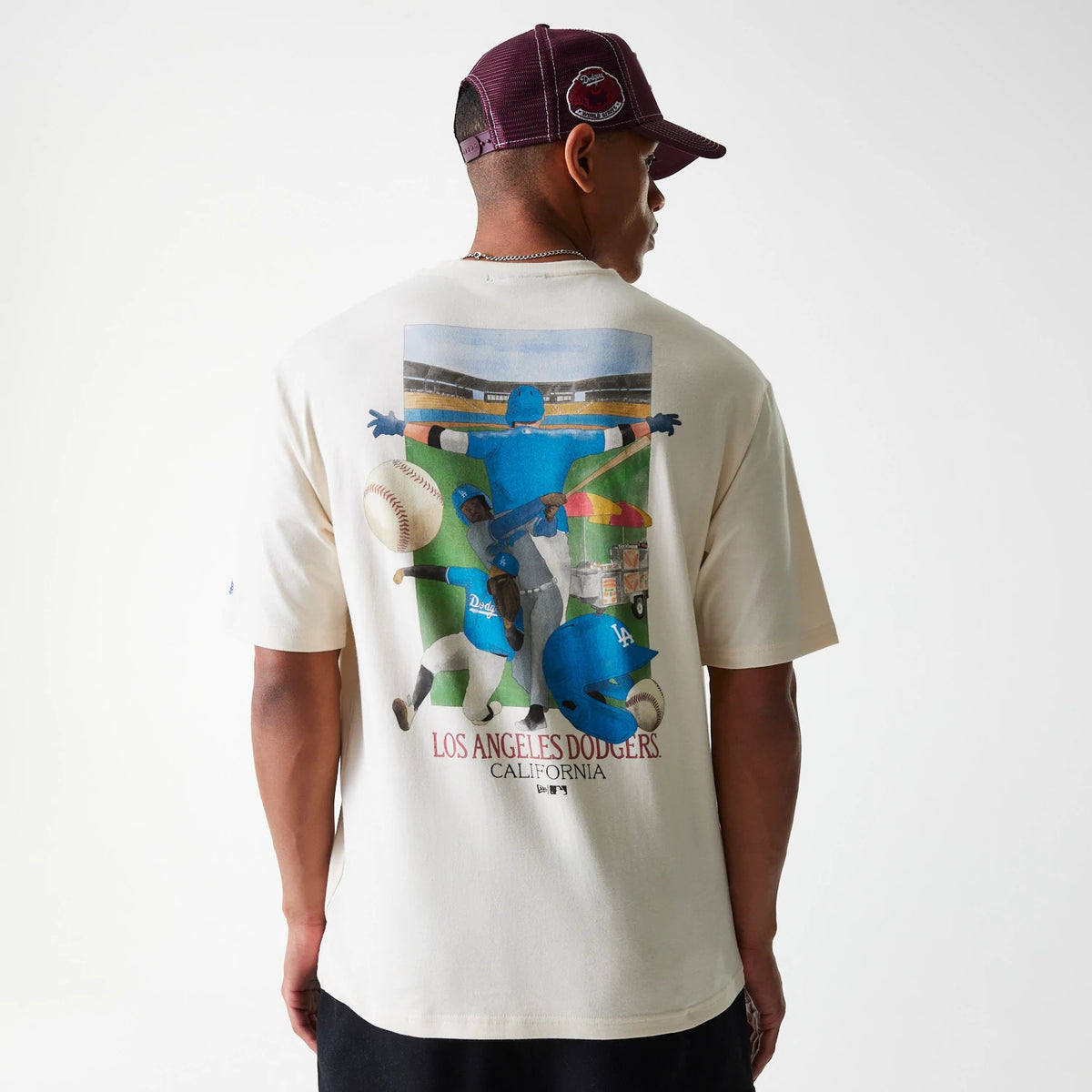 New Era LA Dodgers MLB Baseball Graphic Light Beige Oversized T-Shirt, back view featuring a colourful baseball scene graphic across the upper back, with the words Los Angeles Dodgers California underneath.