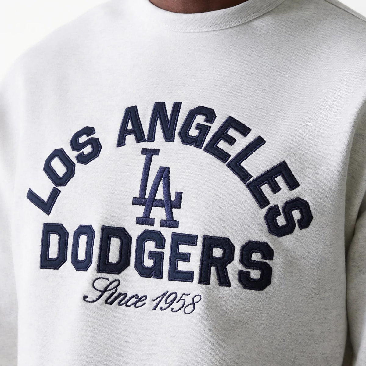 New Era LA Dodgers MLB Heritage Pastel Grey Oversized Crew Neck Sweater, front view showing the blue embroidered LA Dodgers logo and 'Since 1958' lettering, centred on the grey textured fabric of the chest.