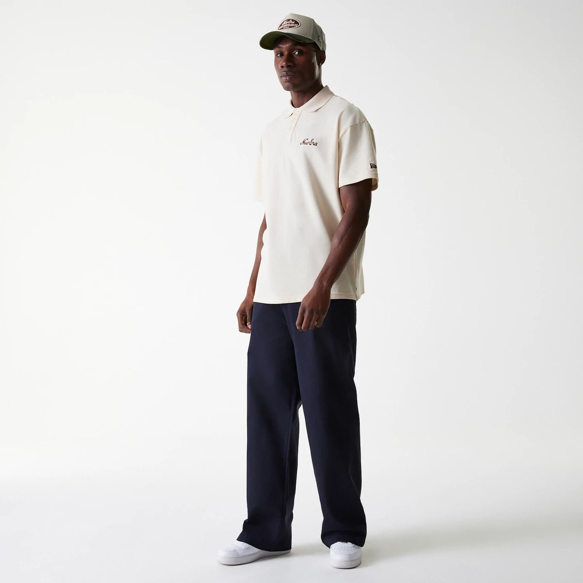 New Era LA Dodgers MLB Navy Chino Trousers, on-model view showing the full-length trousers paired with a light-coloured polo shirt and cap, highlighting the trousers' relaxed fit and straight leg design.