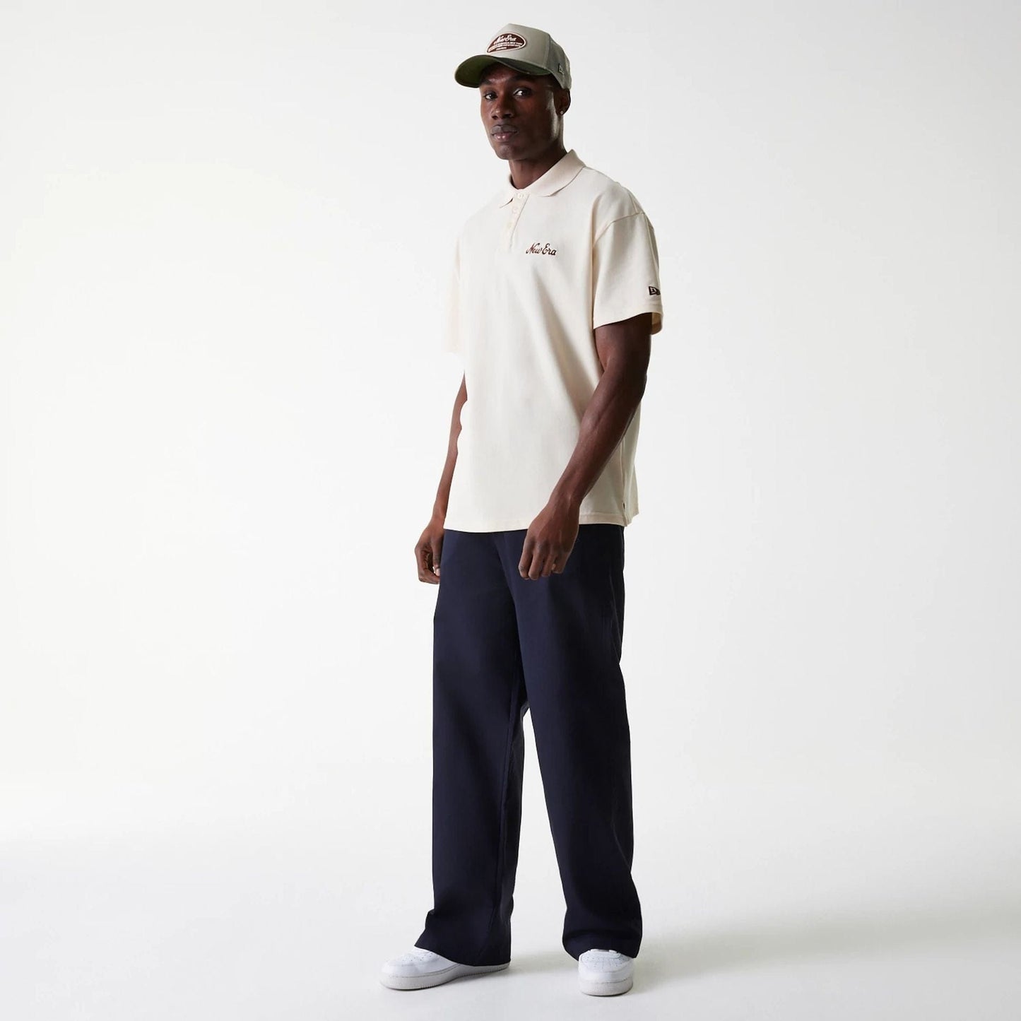 New Era LA Dodgers MLB Navy Chino Trousers, on-model view showing the full-length trousers paired with a light-coloured polo shirt and cap, highlighting the trousers' relaxed fit and straight leg design.