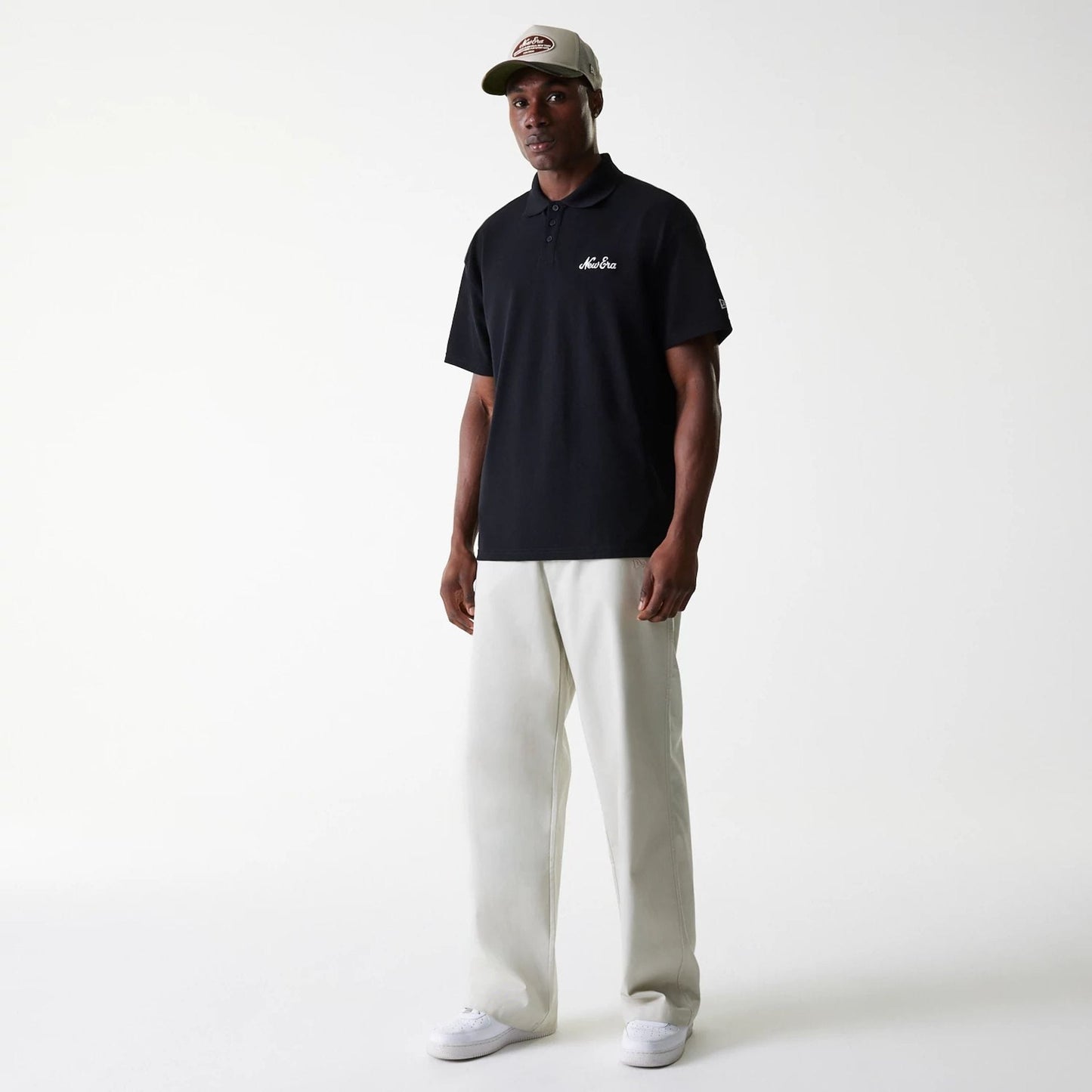 New Era New York Yankees MLB Light Beige Chino Trousers, on-model showing full-length design paired with a black polo shirt and light-coloured trainers, creating a classic casual style.