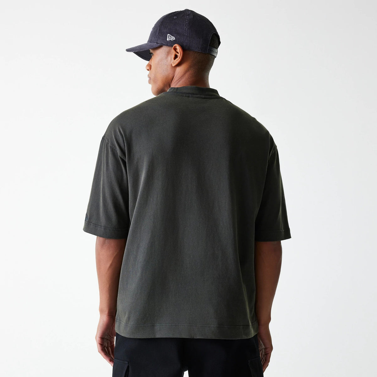 New Era LA Lakers NBA Washed Graphic Grey T-Shirt, on-model rear view showing a plain grey back with relaxed-fit short sleeves, paired with a navy cap that has a raised New Era logo on the side.