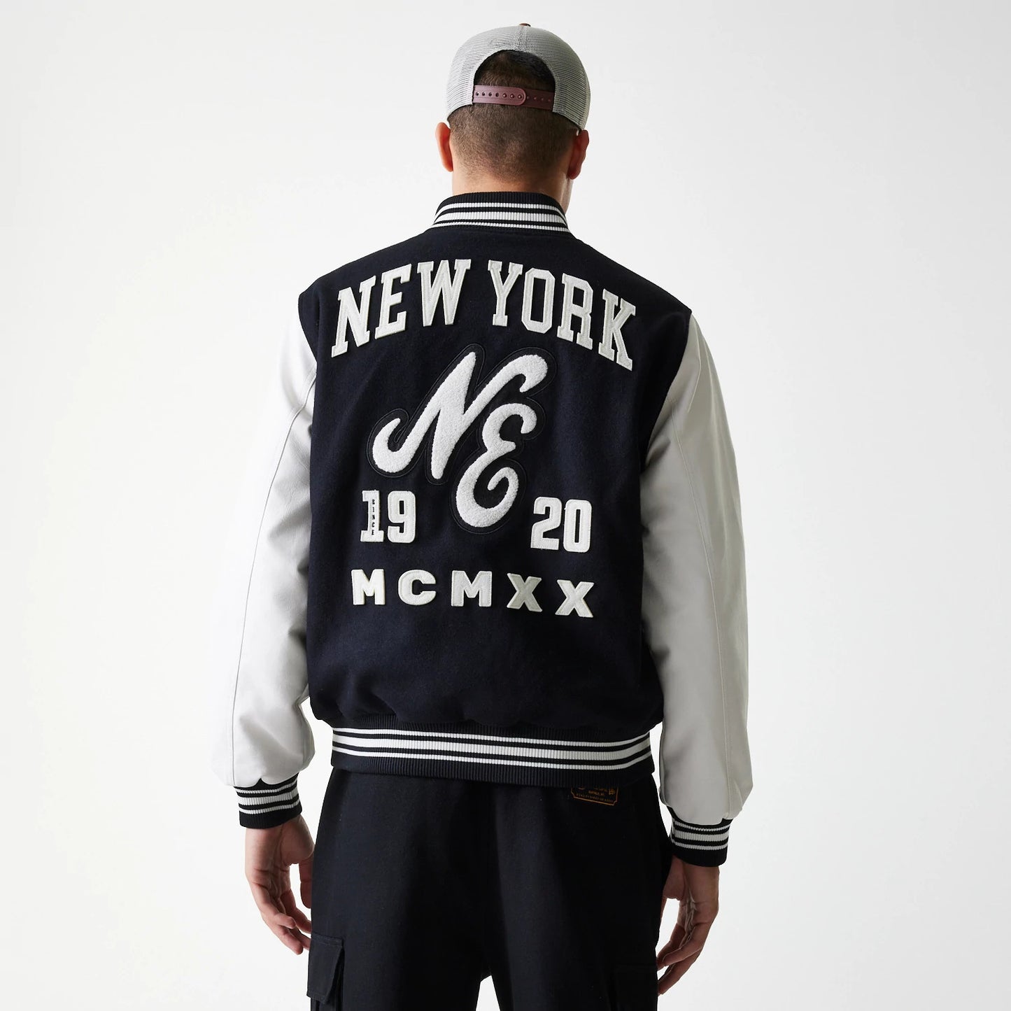The Male model is wearing New Era Patch Black Varsity Jacket 8