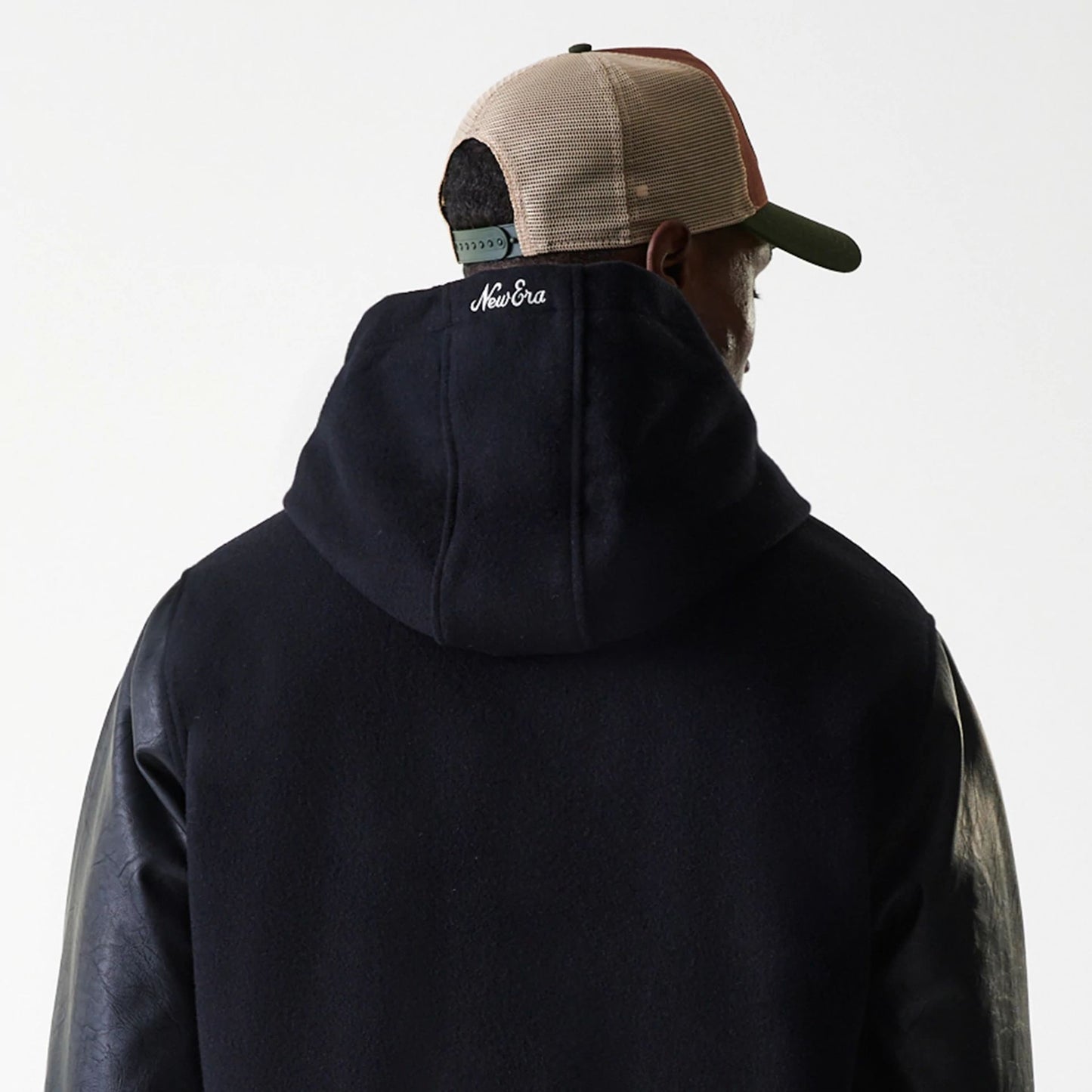 The Male model is wearing New Era Black Hooded Varsity Jacket 7