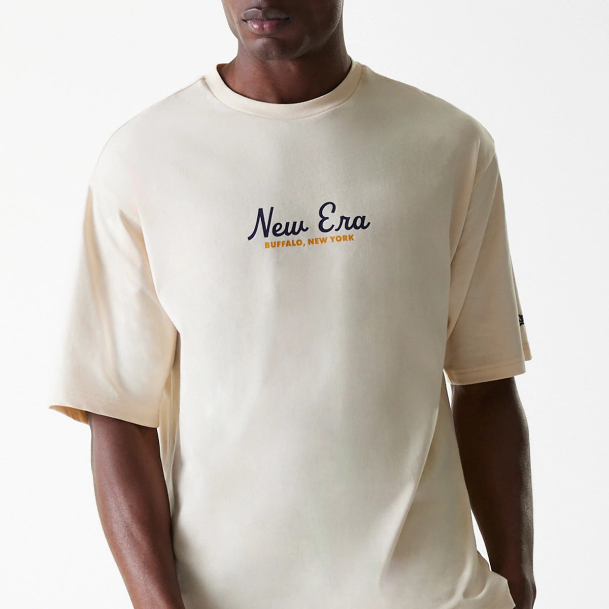 New Era Animal Graphic Light Beige Oversized T-Shirt, front view showing the oversized light beige fit with a navy New Era logo and Buffalo, New York in orange centred on the chest.