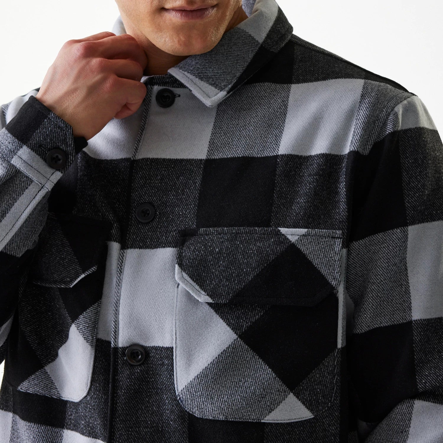 New Era Black Shacket, front view on a model highlighting the large black and grey check pattern, with details of the dual chest pockets and black button fastening, with high collar.
