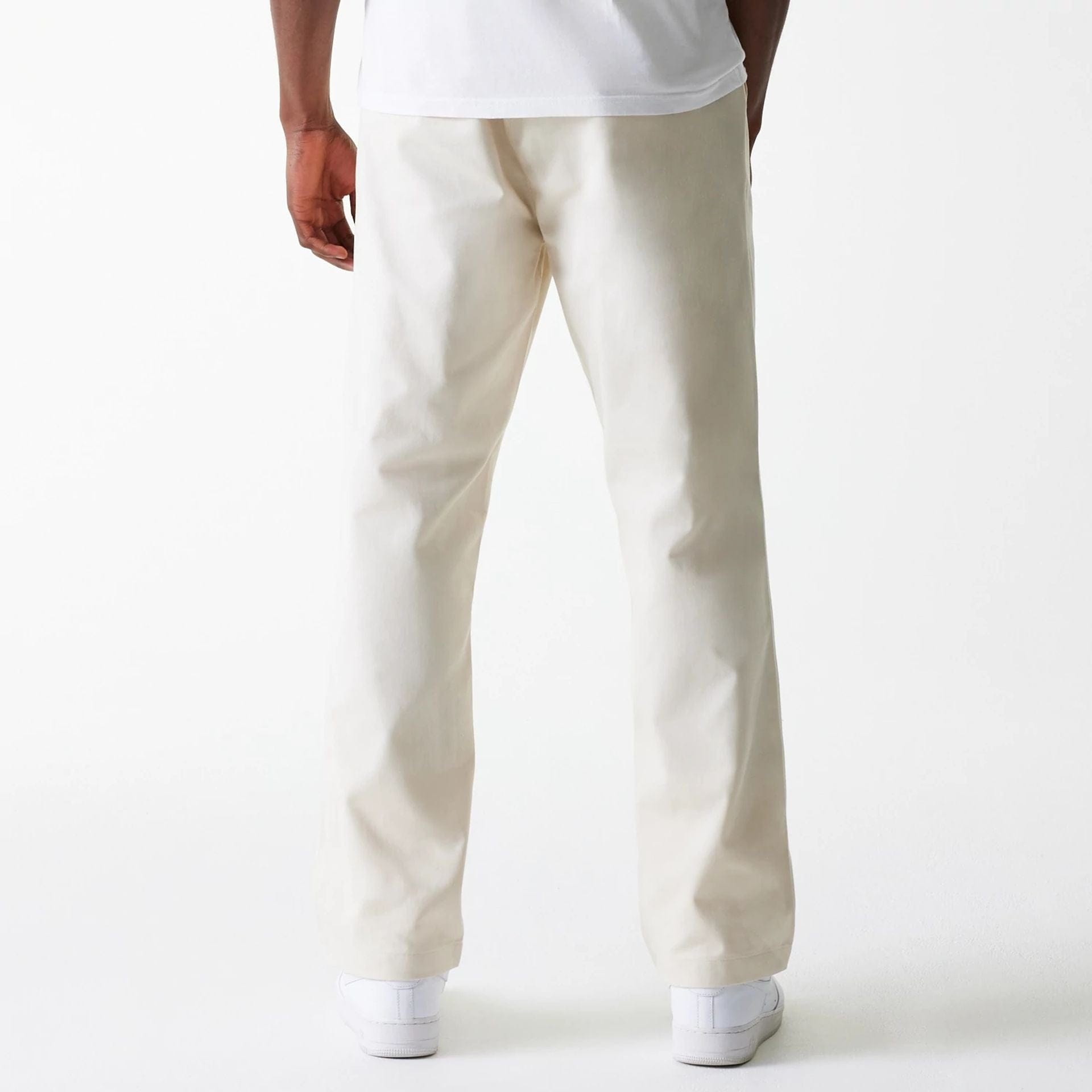 The Male model is wearing New Era Light Beige Chino Trousers 2
