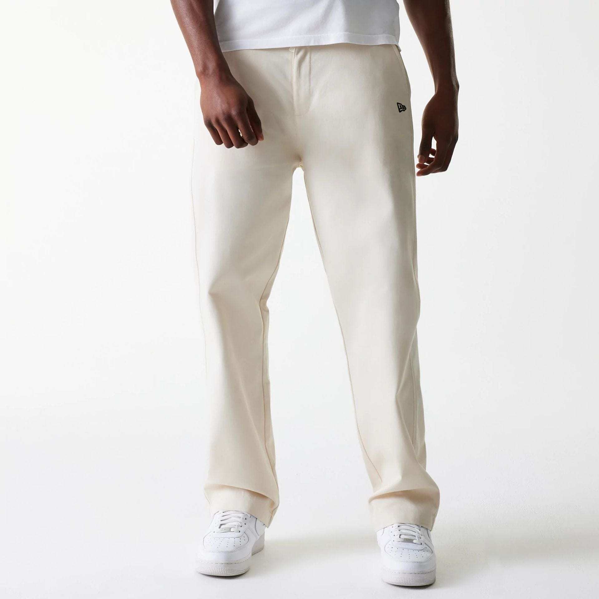 The Male model is wearing New Era Light Beige Chino Trousers 1