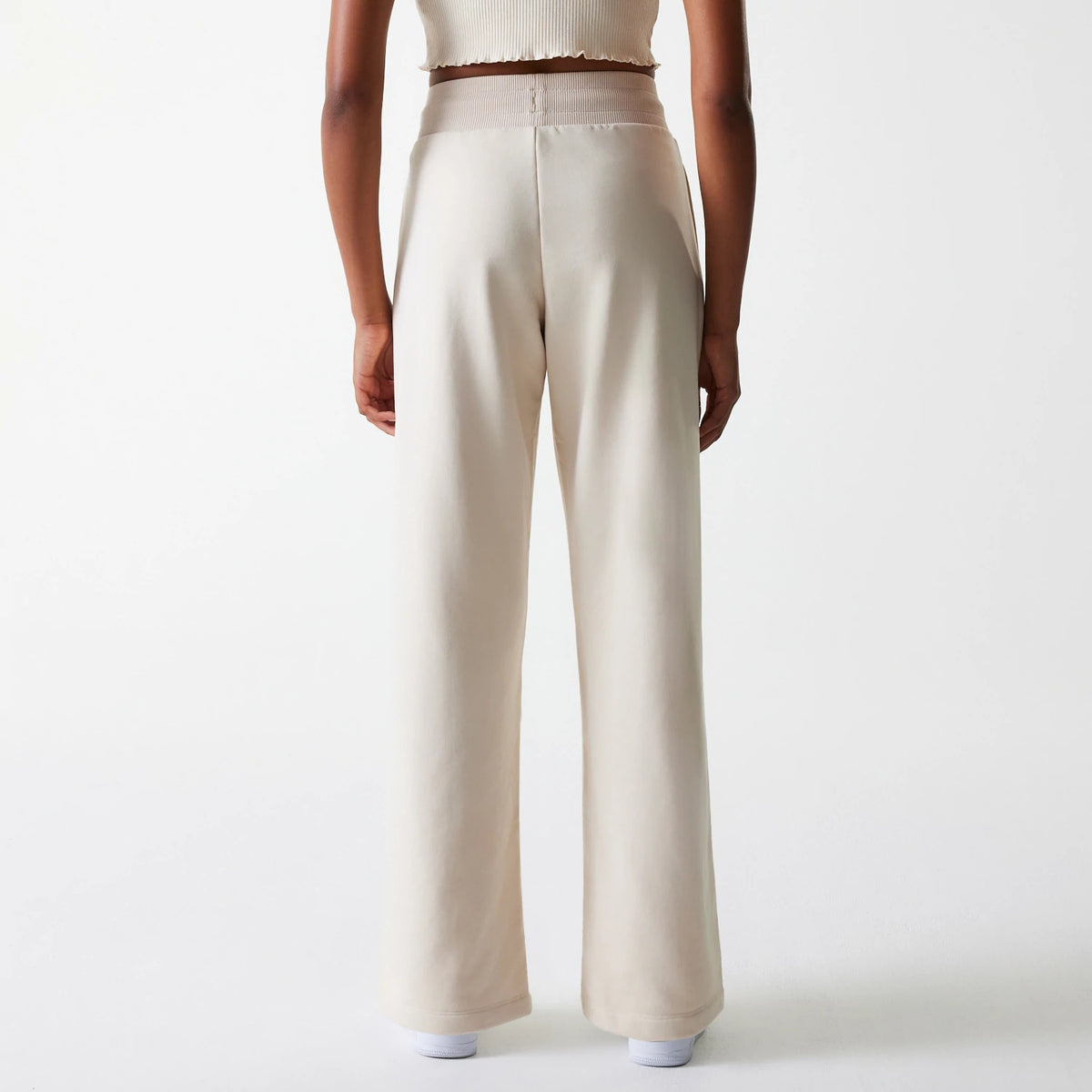 New Era LA Dodgers Womens MLB Tonal Light Beige Straight Leg Joggers, rear view on a model showing the high-waisted ribbed waistband and straight leg fit, with the light beige fabric creating a sleek silhouette.