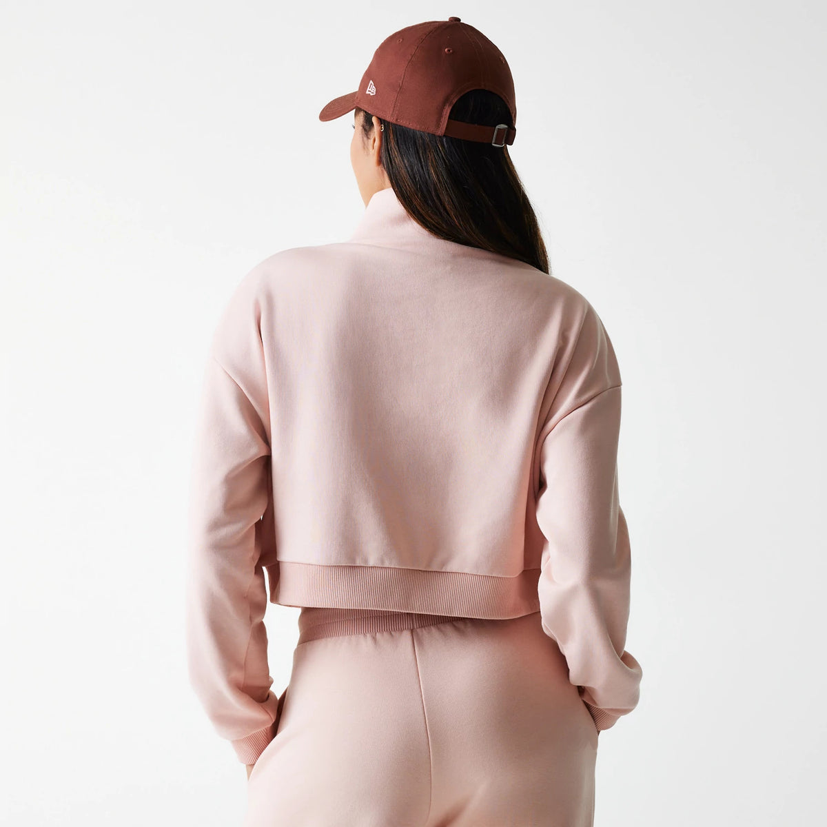 New Era New York Yankees Womens MLB Tonal Pastel Pink Cropped 1/4 Zip Sweater, back view on a model with matching pink trousers and a brown cap, showing the cropped hemline and relaxed fit of the sweater.