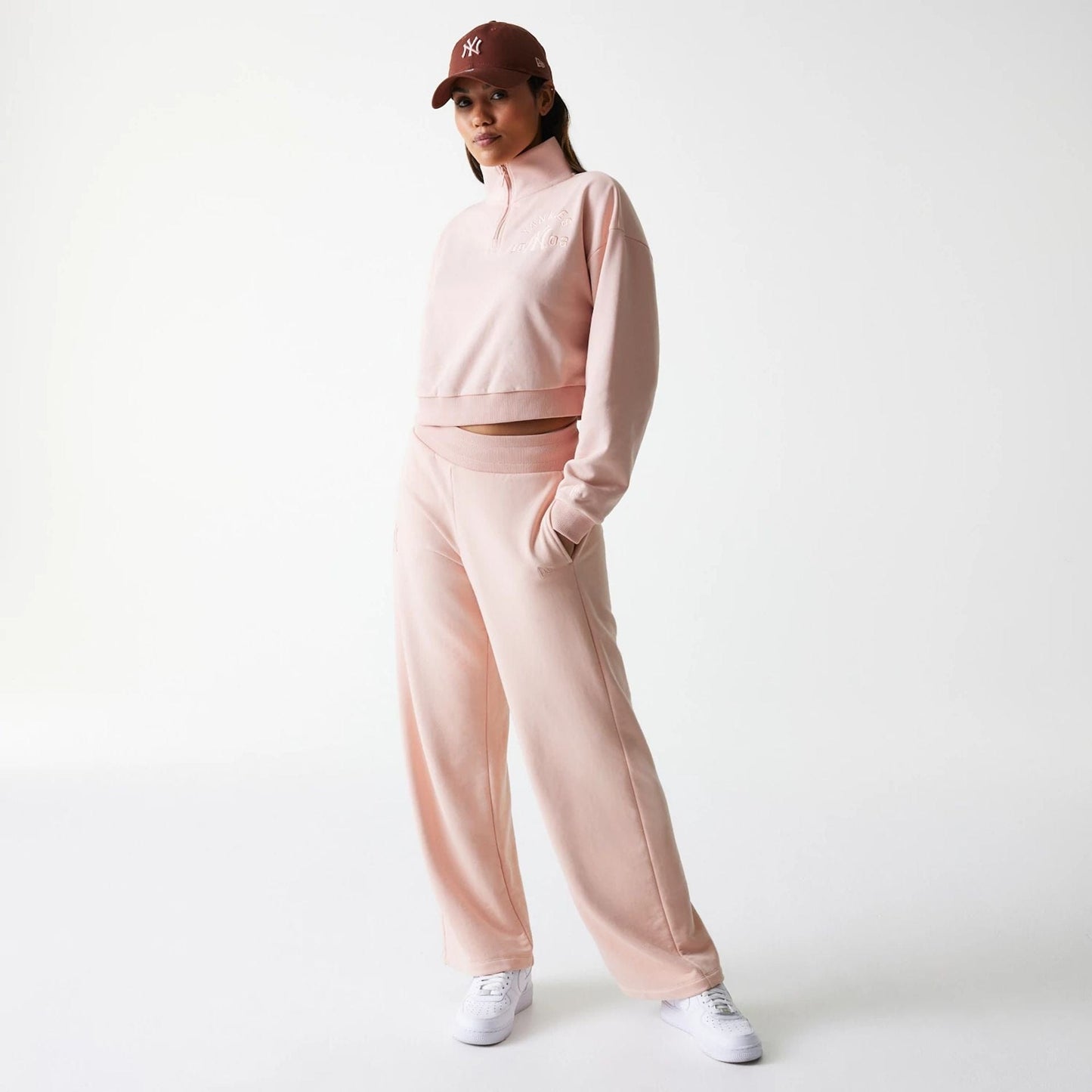 New Era New York Yankees Womens MLB Tonal Pastel Pink Cropped 1/4 Zip Sweater, on a model styled with matching pink joggers and white trainers, featuring subtle embroidered logo on the chest and a relaxed fit for casual comfort.