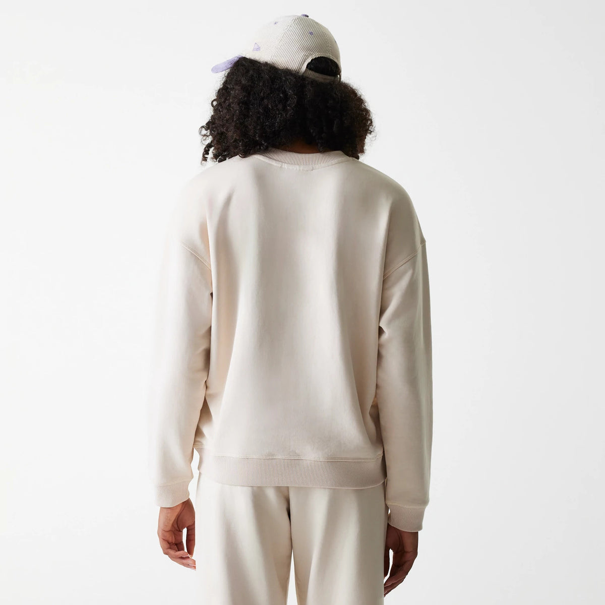 New Era LA Dodgers Womens MLB Tonal Graphic Light Beige Oversized Crew Neck Sweater, back view on a model with matching light beige trousers, showing the relaxed fit and ribbed collar and cuffs.