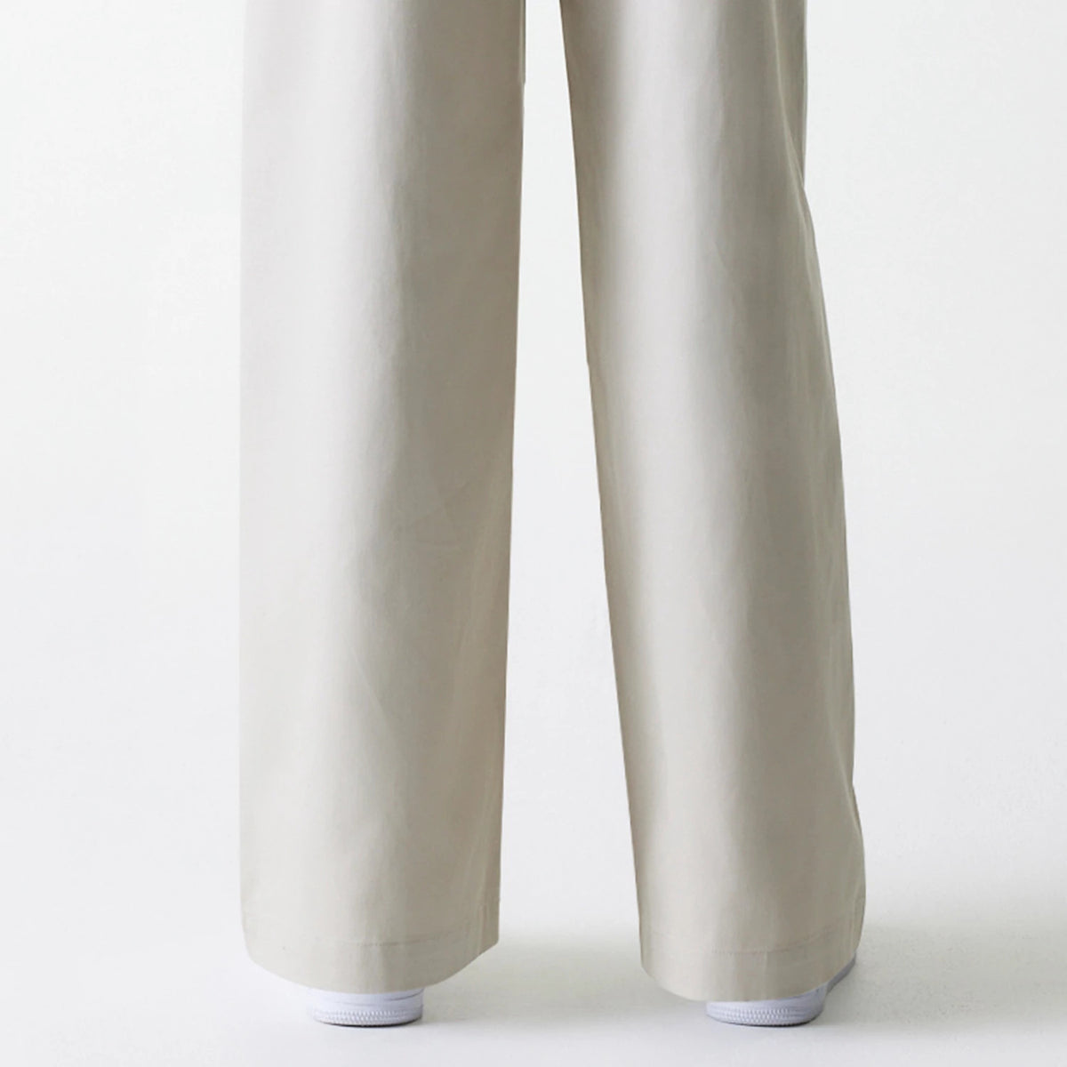 Womens New Era Light Beige Wide Leg Chino Trousers, front view showing the full-length wide leg cut and light beige colour, partly covering white sneakers at the hems.
