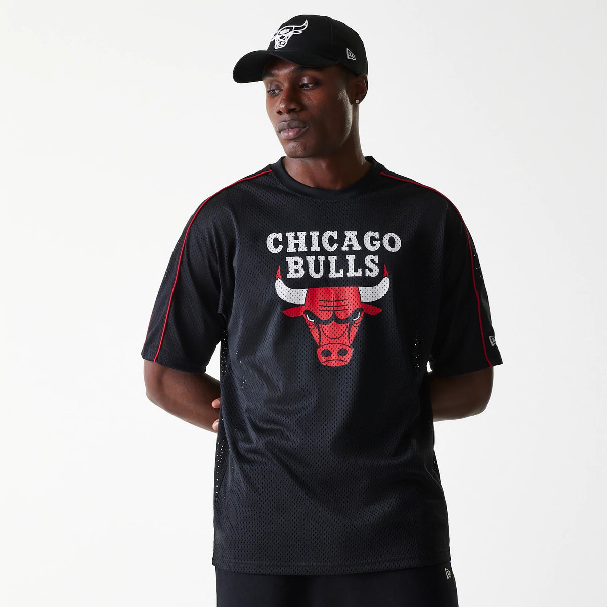 New Era Chicago Bulls NBA Piping Black Oversized Mesh T-Shirt, on-model view showing a black mesh t-shirt with red piping along the shoulders and sleeves, featuring a large printed Chicago Bulls logo on the front centre.