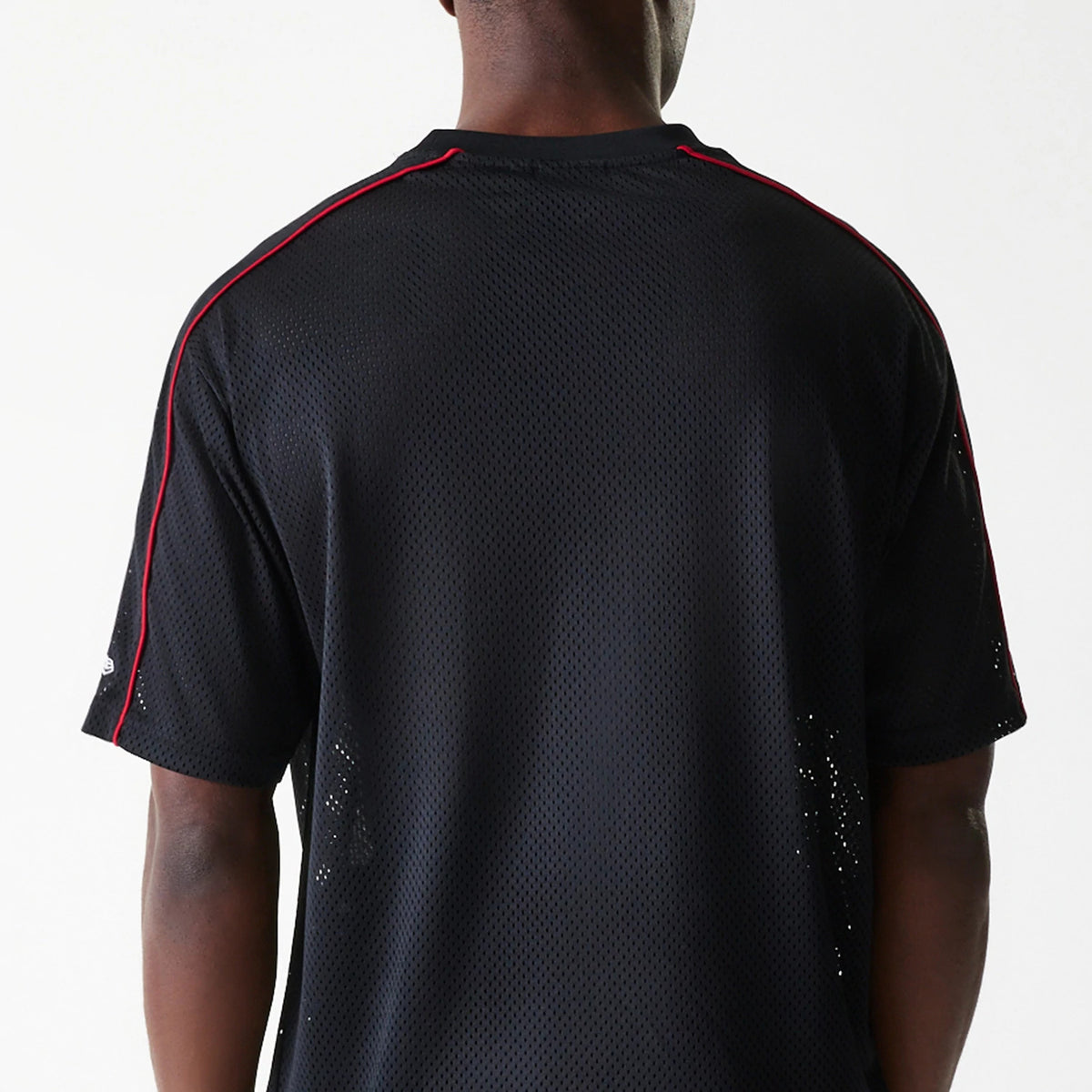 New Era Chicago Bulls NBA Piping Black Oversized Mesh T-Shirt, rear view showing the black mesh fabric with red piping along the shoulders and sleeves, the loose fit and a single debossed logo on the sleeve.