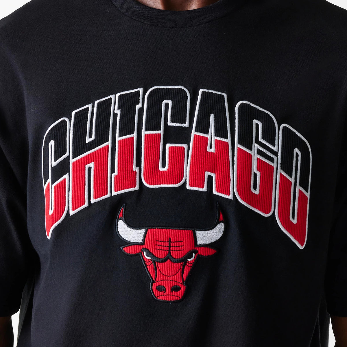 New Era Chicago Bulls NBA Arch Graphic Black Oversized T-Shirt, front view showing the large white and red embroidered CHICAGO text and raised Bull logo on the chest of the black fabric.