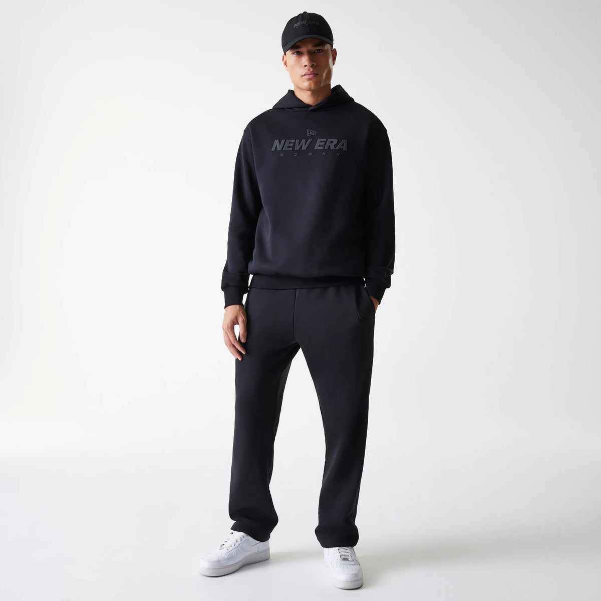 The Male model is wearing New Era Tech Black Oversized Pullover Hoodie 8