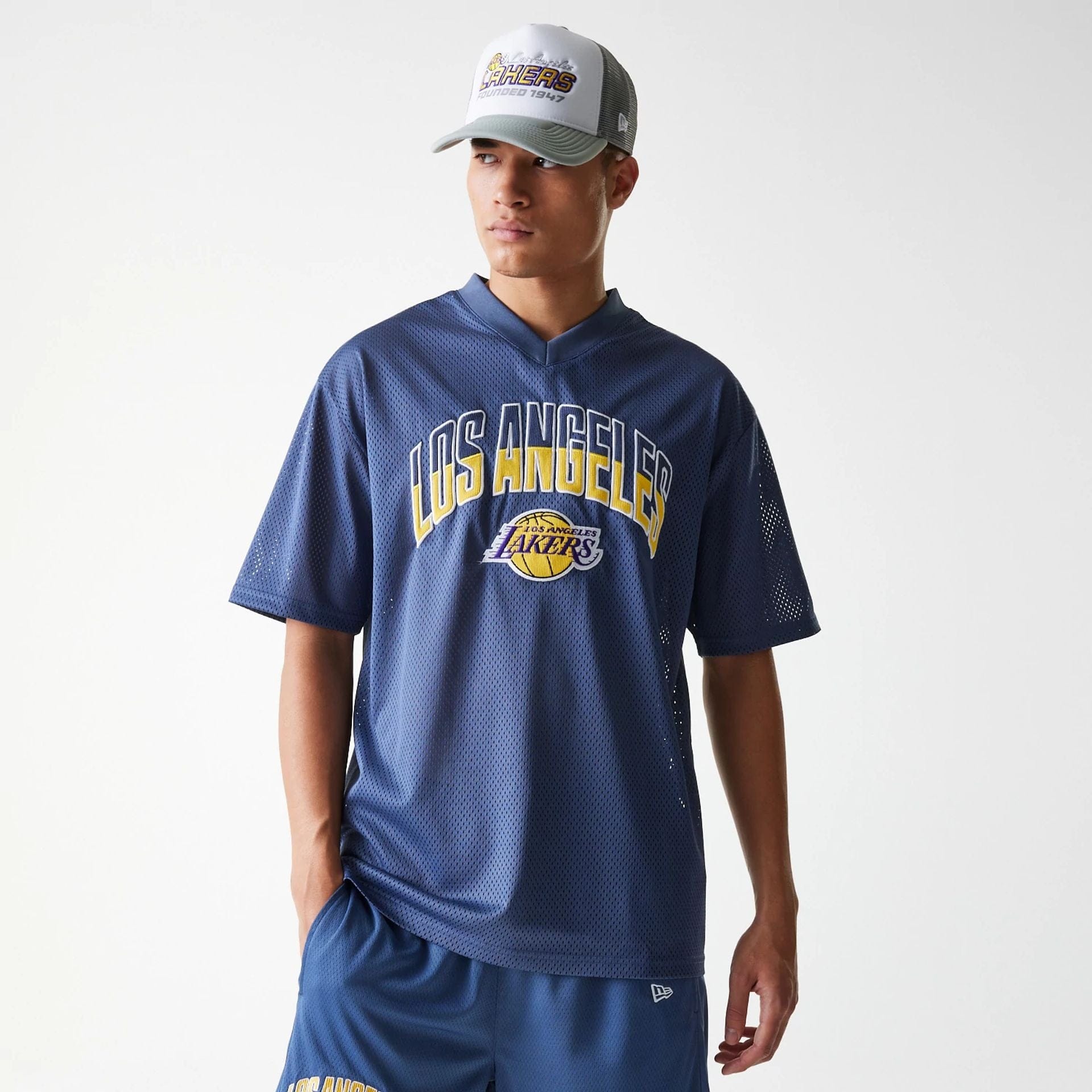 The Male model is wearing LA Lakers NBA Arch Dark Blue Mesh Oversized Jersey 1