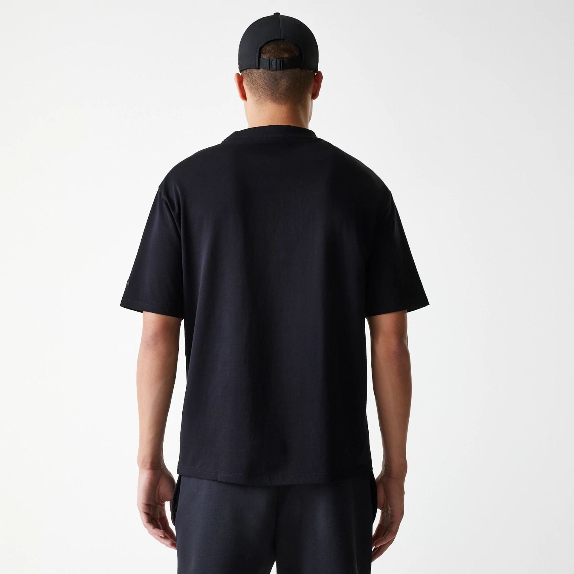 The Male model is wearing New Era Tech Black Oversized T-Shirt 2