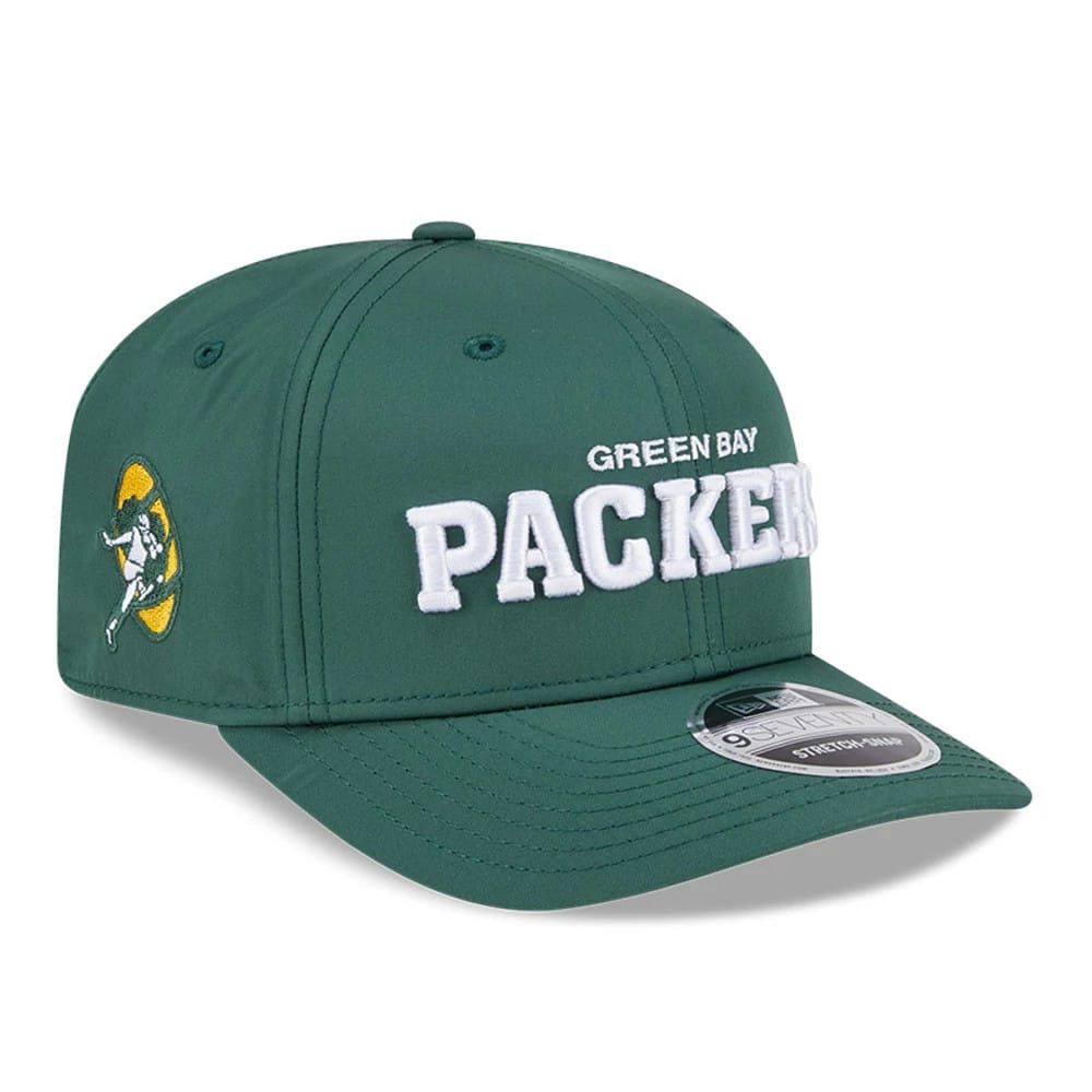 Green Bay Packers NFL Coach Dark Green New Era 9SEVENTY Stretch Snap Adjustable Cap, three-quarter view showing white raised embroidery logo on front panel, with a side patch logo and a grey 9SEVENTY size sticker on the dark green curved visor.