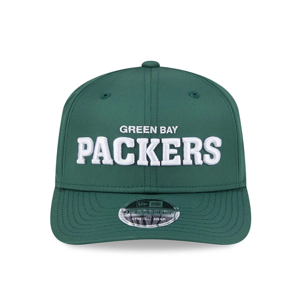 Green Bay Packers NFL Coach Dark Green New Era 9SEVENTY Stretch Snap Adjustable Cap, front view showing raised white embroidered 'Packers' lettering on the structured dark green crown, with a reflective 9SEVENTY size sticker on the flat visor.