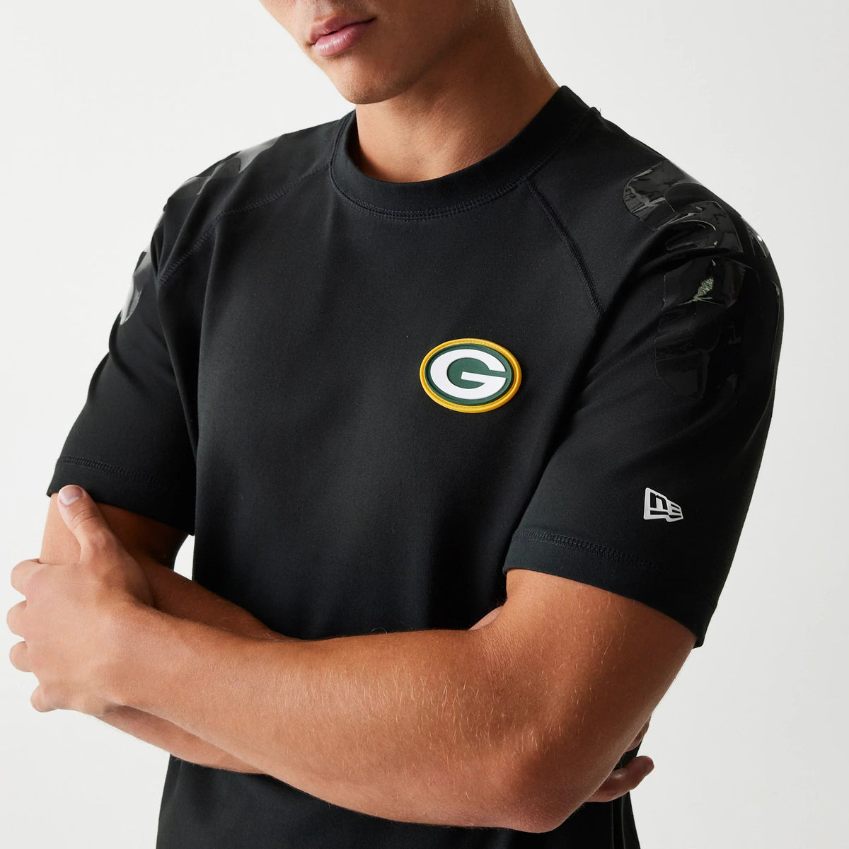 New Era Green Bay Packers NFL 3RD Down Black T-Shirt, front view on-model showing the raised team logo centred on the chest, New Era embroidered logo on the sleeve, and glossy black on the shoulders.