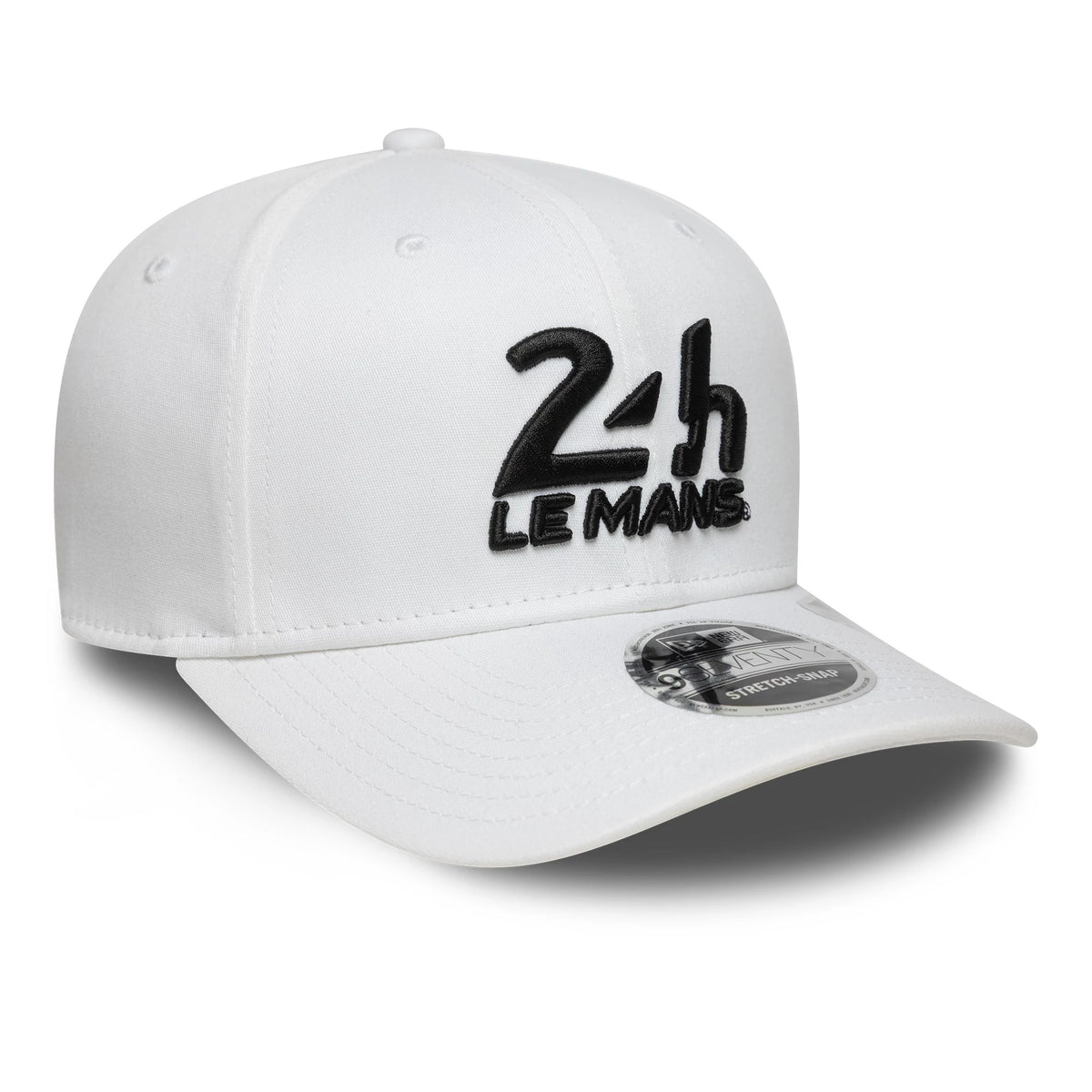 24HR Le Mans Core White New Era 9SEVENTY Stretch Snap Adjustable Cap, three-quarter view showing a raised black embroidered 24H Le Mans logo on the front panel, with a white curved visor and 9SEVENTY size sticker.