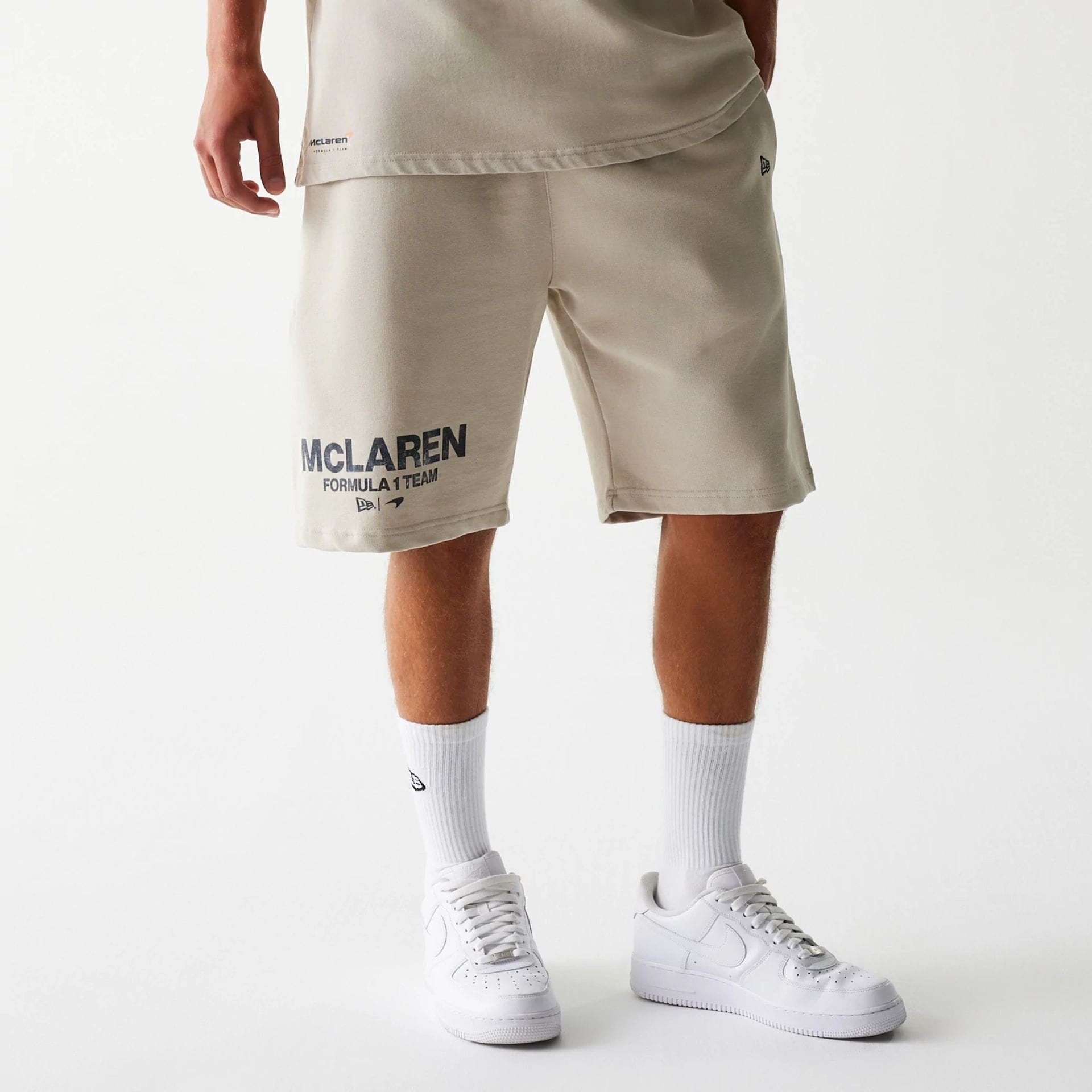The Male model is wearing McLaren Racing Wordmark Light Beige Oversized Shorts 1