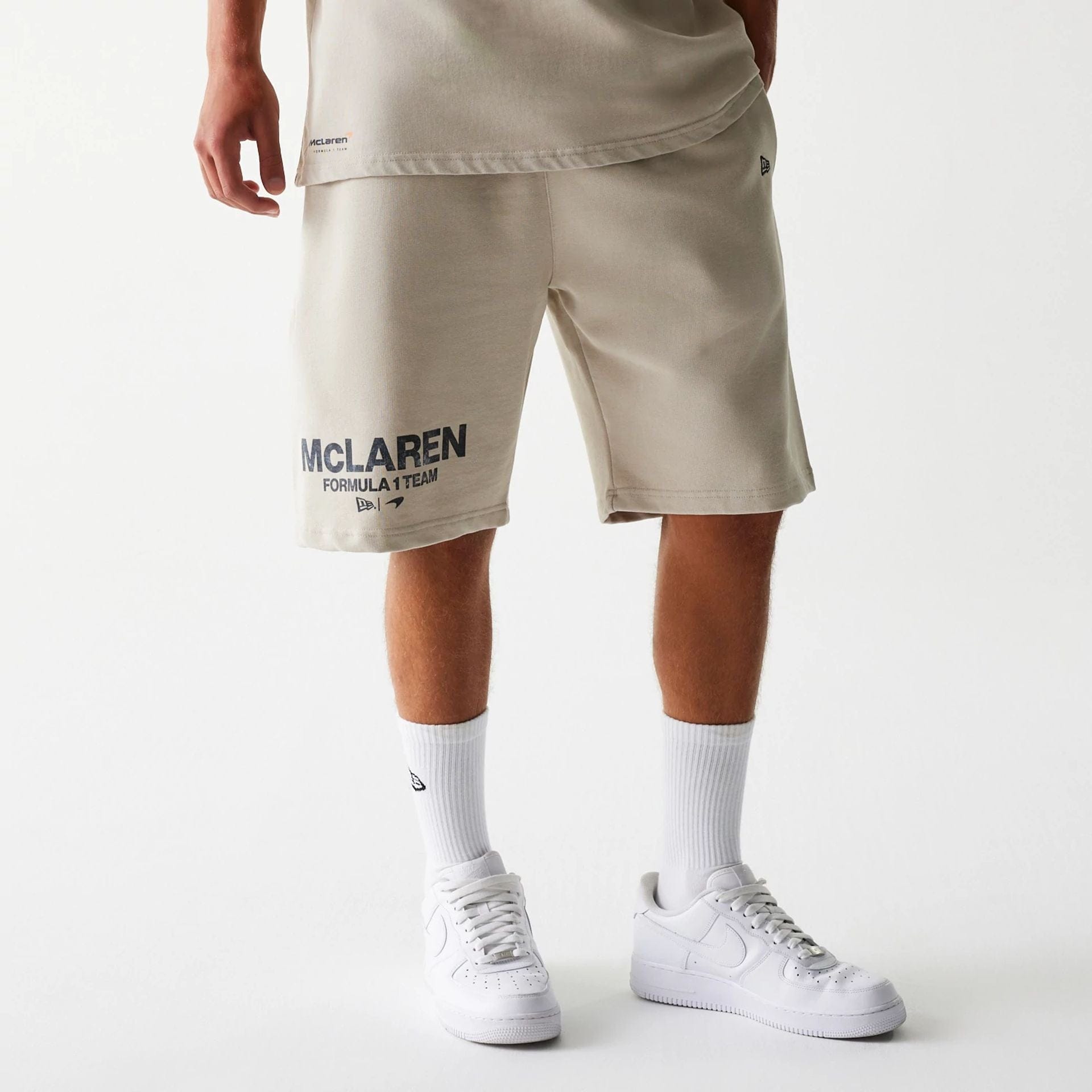 The Male model is wearing McLaren Racing Wordmark Light Beige Oversized Shorts 1