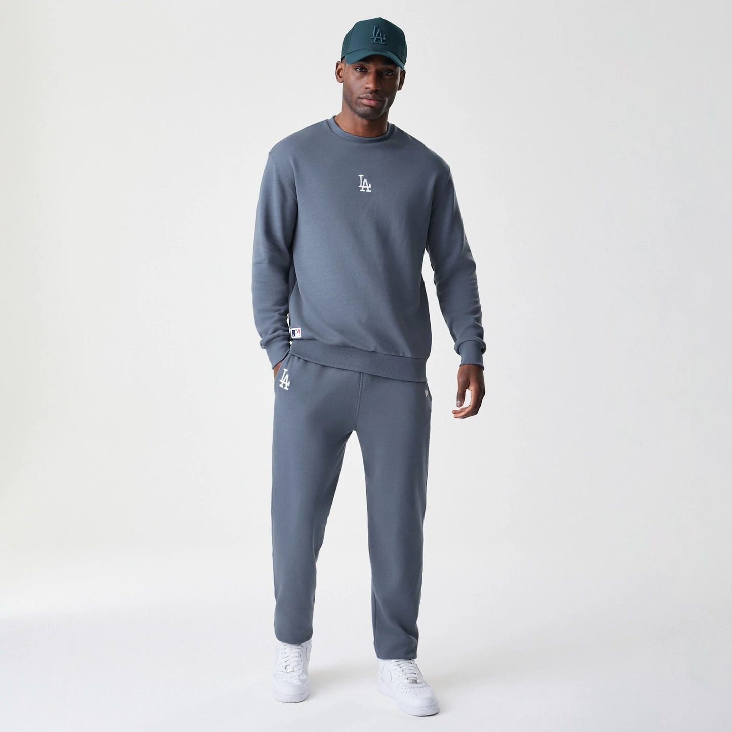 New Era LA Dodgers MLB Midi League Essential Dark Grey Oversized Crew Neck Sweater, on-model view showing the white LA logo embroidered on the left chest and a relaxed fit, paired with matching dark grey joggers.