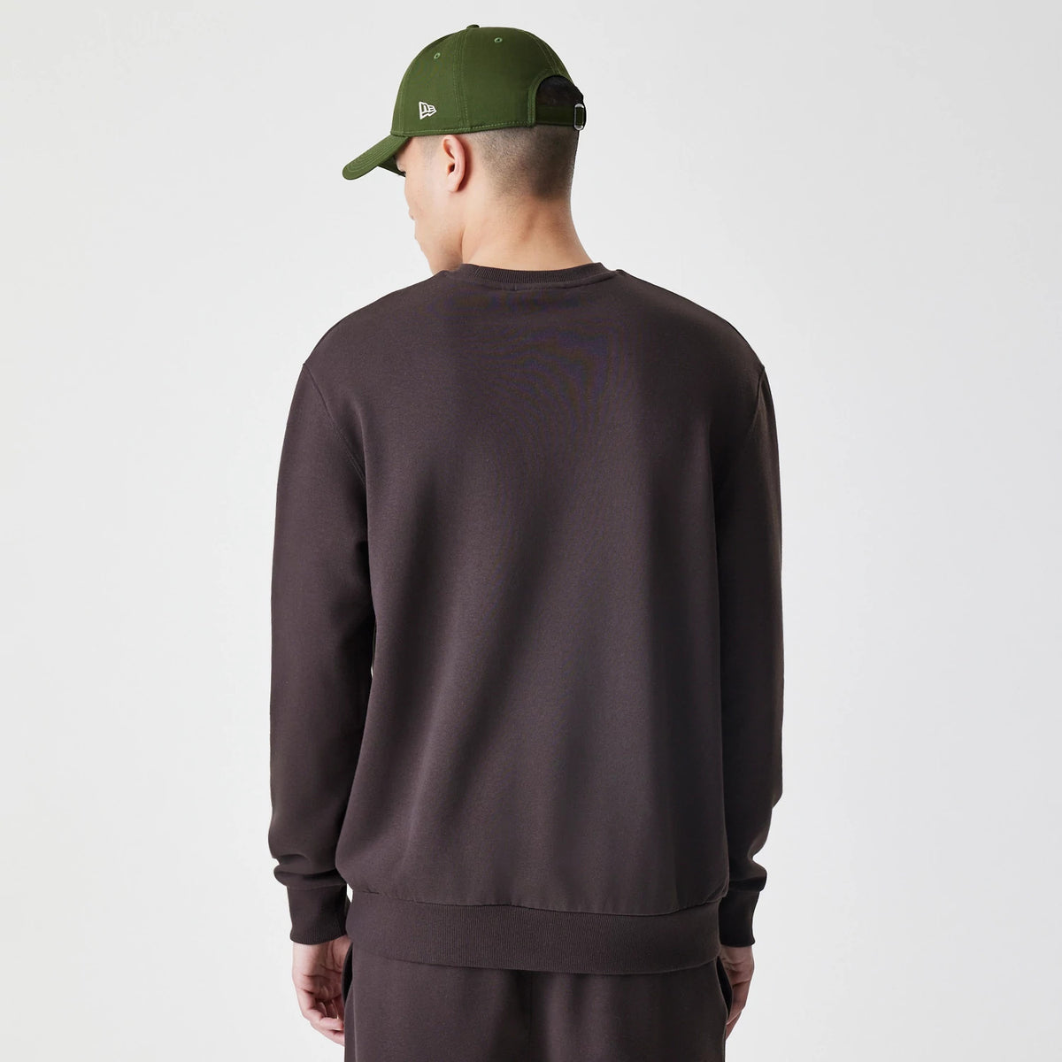 New Era New York Yankees MLB Midi League Essential Dark Brown Oversized Crew Neck Sweater, back view on a model showing the dark brown fabric and relaxed fit with ribbed cuffs and hem.