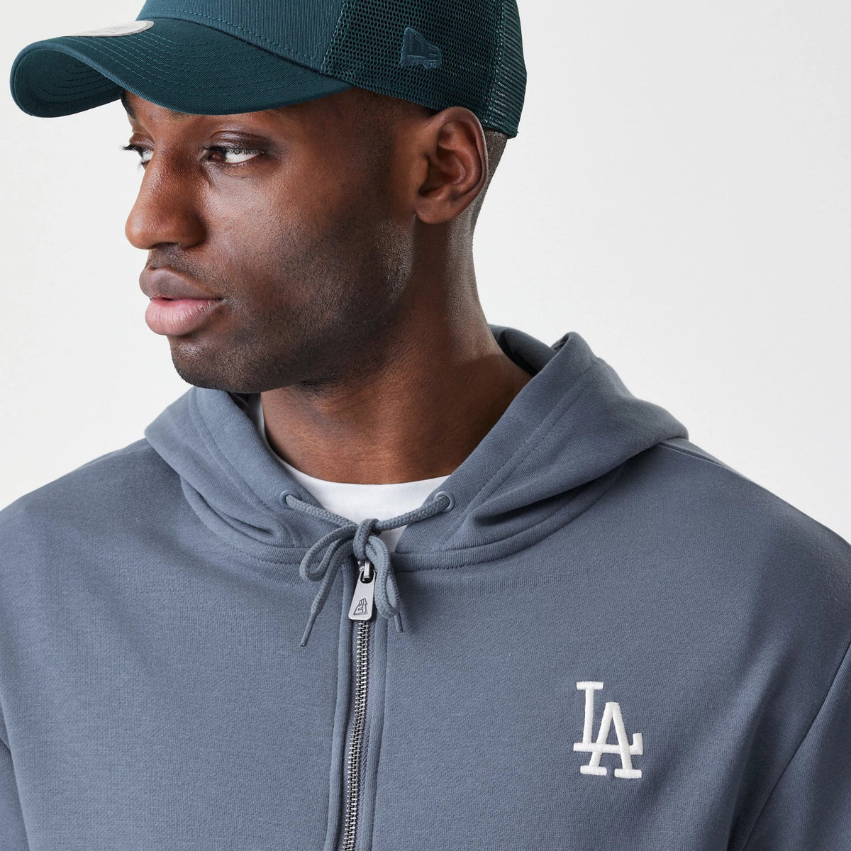 New Era LA Dodgers MLB Midi League Essential Dark Grey Full Zip Hoodie, front view on a model showing the white embroidered LA logo on the left chest, the full-length zip with a round drawstring at the hood.