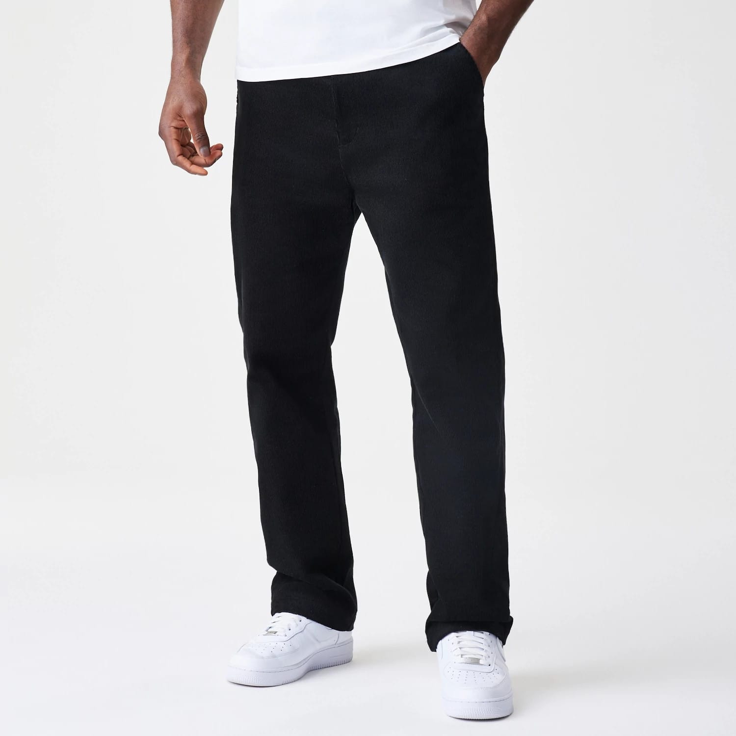 New Era Cord Black Straight Leg Chinos, front view showing the texture and classic straight leg cut, paired with a plain white t-shirt and white trainers, highlighting the casual yet design.