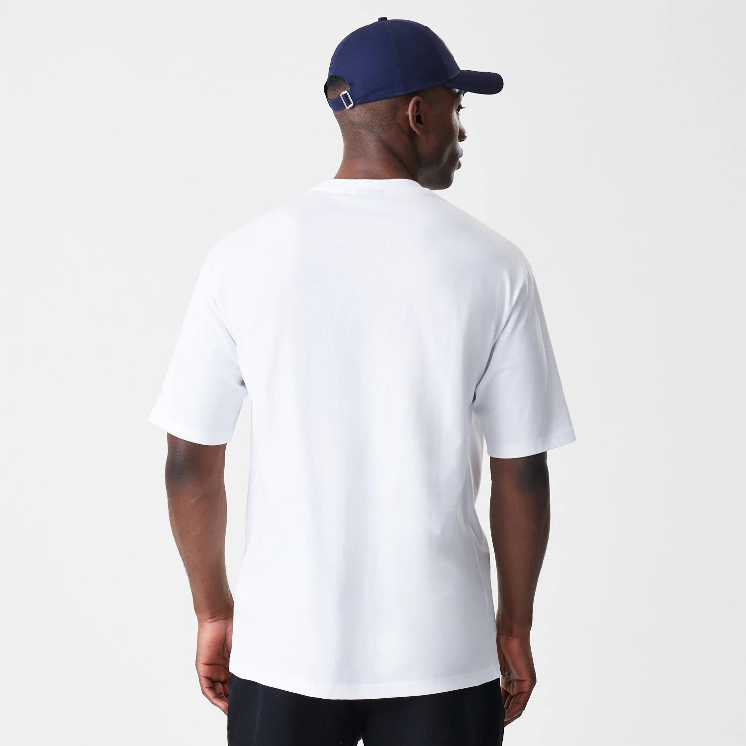 New Era Floral White Oversized T-Shirt, back view showing the plain white fabric with a straight hem, no graphics or logos, worn on-model with the focus on the relaxed fit and short sleeves.