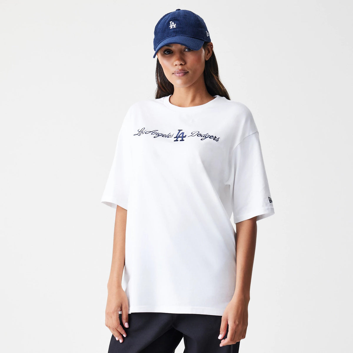New Era LA Dodgers MLB Script White Oversized T-Shirt, front view on-model displaying the scripted Los Angeles Dodgers text across the chest in navy with an LA logo, and a small embroidered New Era logo on the left sleeve.