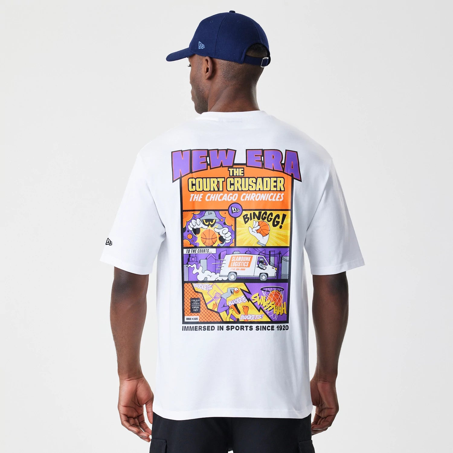 New Era Location White Oversized T-Shirt, back view on a model with a blue cap, featuring a graphic of a comic strip in purple, orange and yellow with New Era lettering across the top.