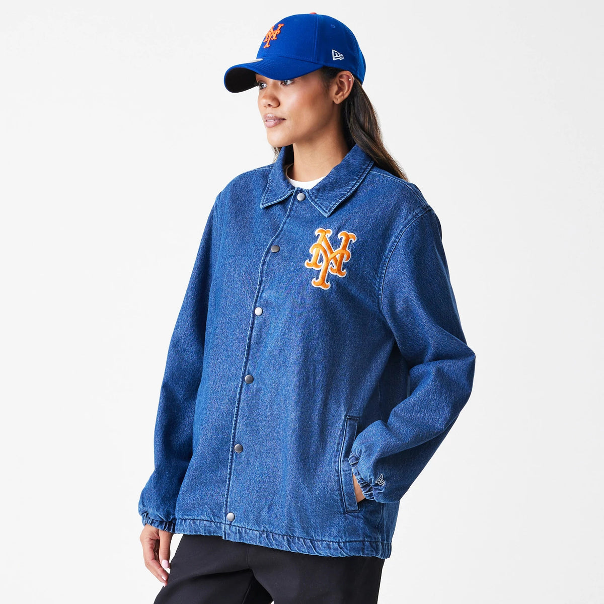 New Era New York Mets MLB Denim Dark Blue Coaches Jacket, front view on-model showing orange embroidered Mets logo on the chest, button-up closure, collared neckline, and elasticated cuffs.