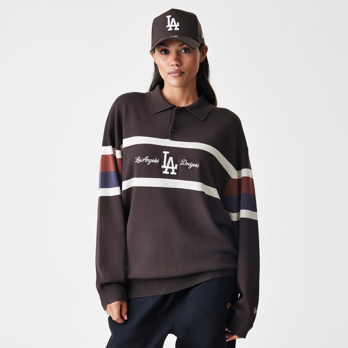 New Era LA Dodgers MLB Knit Brown Rugby Shirt, front view on a model wearing a matching cap, showing the Los Angeles Dodgers logo centred between two white horizontal stripes across the chest, with contrasting brown and blue accents on the sleeves.