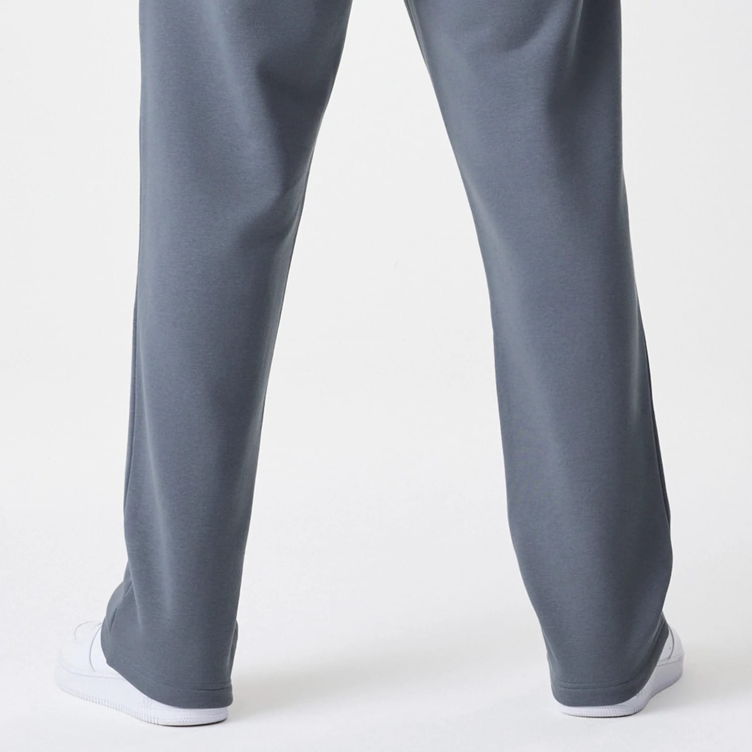 New Era LA Lakers NBA Linear Dark Grey Straight Leg Joggers, rear view showing the plain dark grey design with a relaxed straight leg fit, extending to white trainers at the hem.