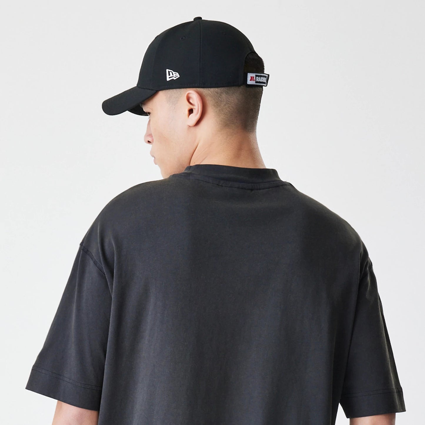 The Male model is wearing Las Vegas Raiders NFL Washed Boxy Dark Grey Oversized T-Shirt 7
