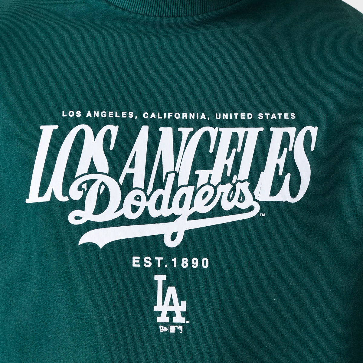 New Era LA Dodgers MLB Script Dark Green Crew Neck Sweater, close-up showing white printed Los Angeles Dodgers script logo across the chest with 'Los Angeles, California, United States' above and 'Est. 1890' and LA logo below.