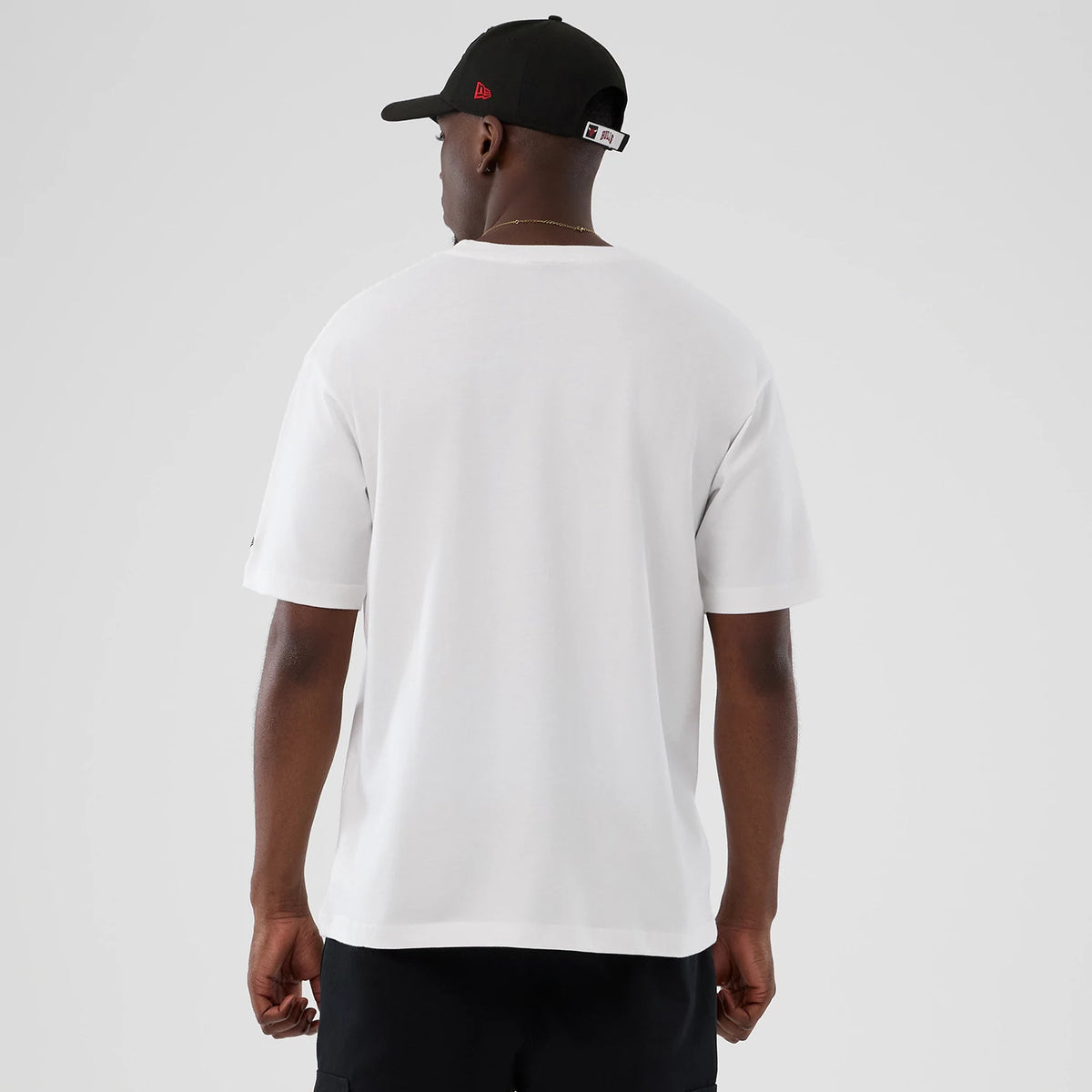 New Era Chicago Bulls NBA Lifestyle Graphic White T-Shirt, back view showing the plain white fabric and relaxed fit on a model paired with a black cap, with no graphics or logos on the back.