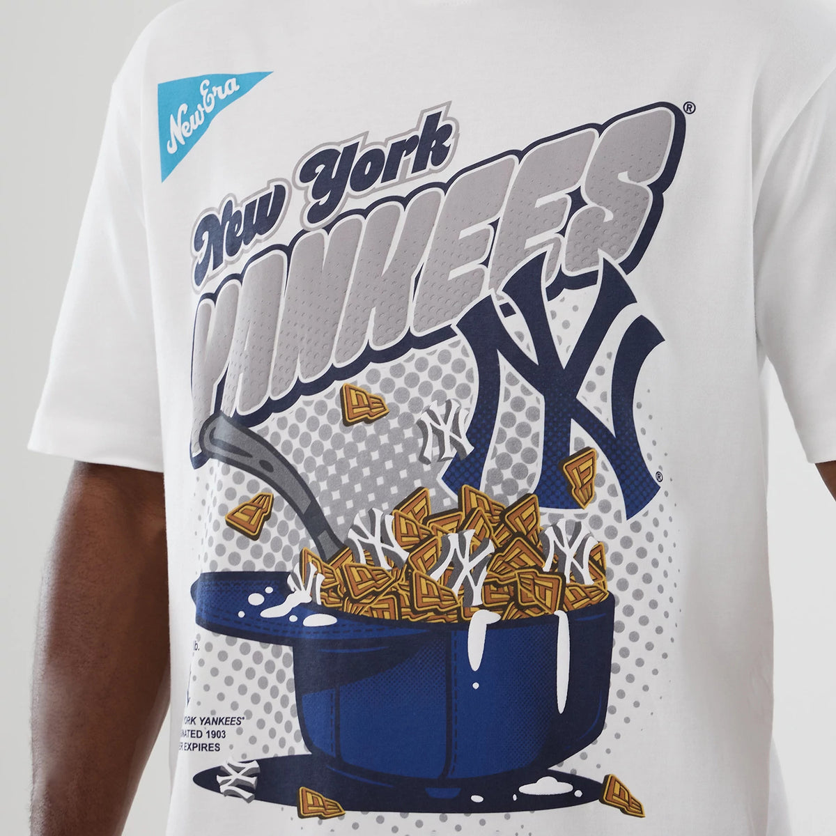 New Era New York Yankees MLB Lifestyle Graphic White T-Shirt, front view showing a large printed graphic of cereal and milk in a baseball cap, with New York Yankees lettering and a blue embroidered New Era logo on the chest.