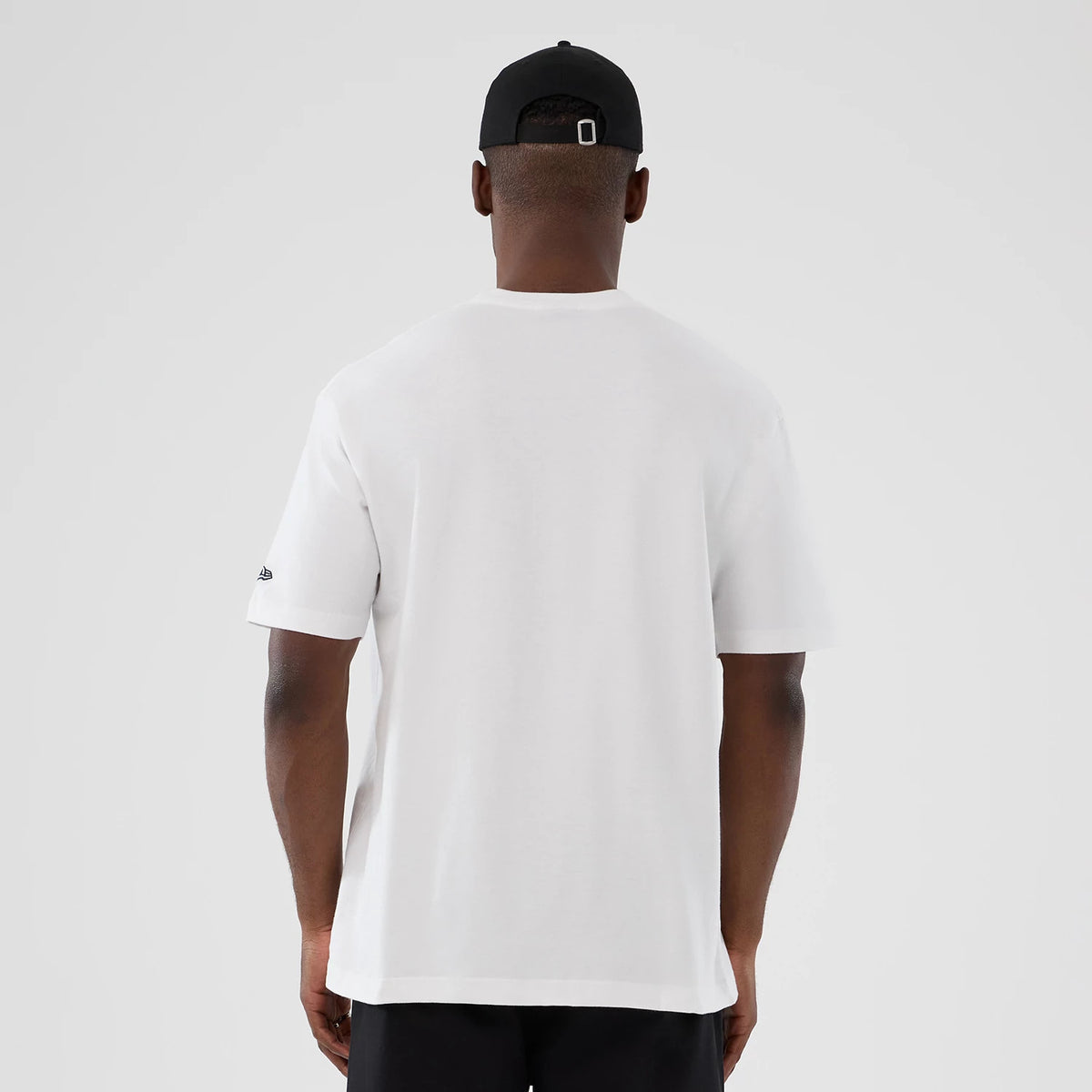 New Era New York Yankees MLB Lifestyle Graphic White T-Shirt, back view on a model wearing a black cap, showing a plain white back with a small embroidered New Era logo on the left sleeve.