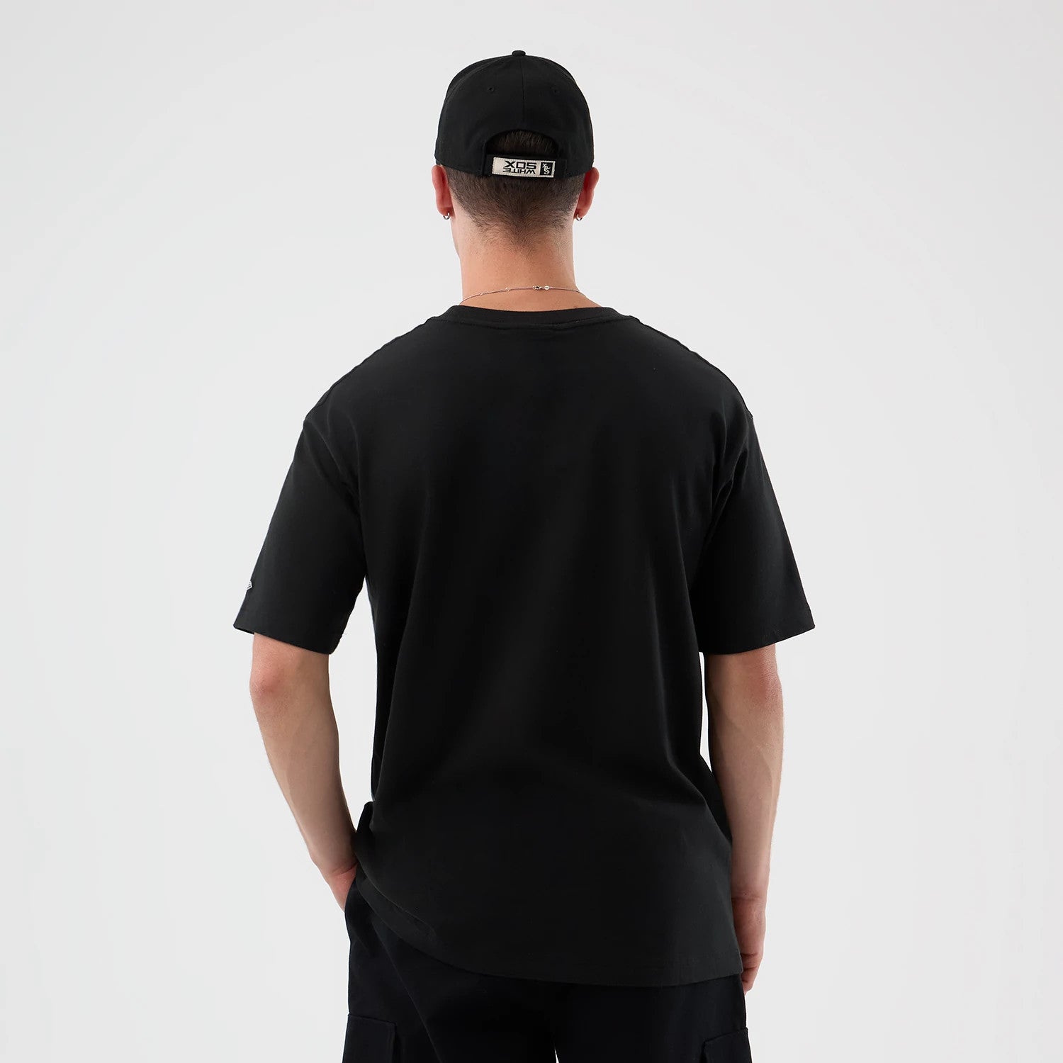 New Era Chicago White Sox MLB Sport Classic Black T-Shirt, back view on a model wearing a matching cap, showing a plain black design with a relaxed fit, emphasising the simplicity and classic look of the t-shirt.