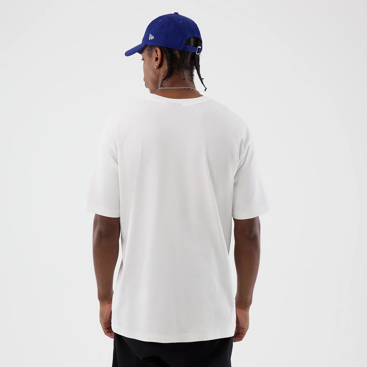 New Era LA Dodgers MLB Sport Script Classic White T-Shirt, back view on a model wearing a blue cap, showing the plain white back of the T-shirt with the straight hem reaching below the waist.