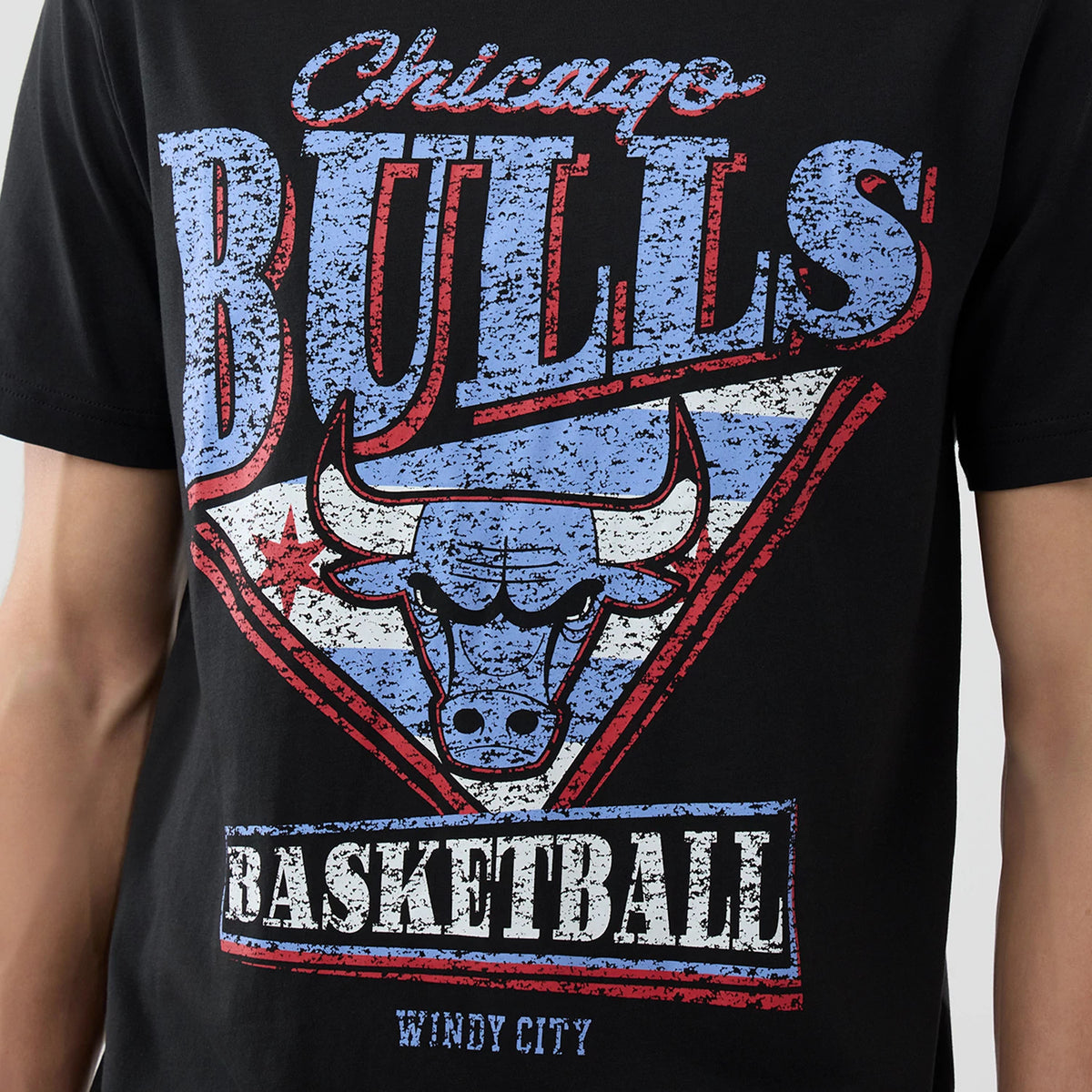 New Era Chicago Bulls NBA City Edition Black T-Shirt, front view showing the distressed graphics of the Chicago Bulls logo in red, white, and blue on the chest with additional Basketball and Windy City text below.