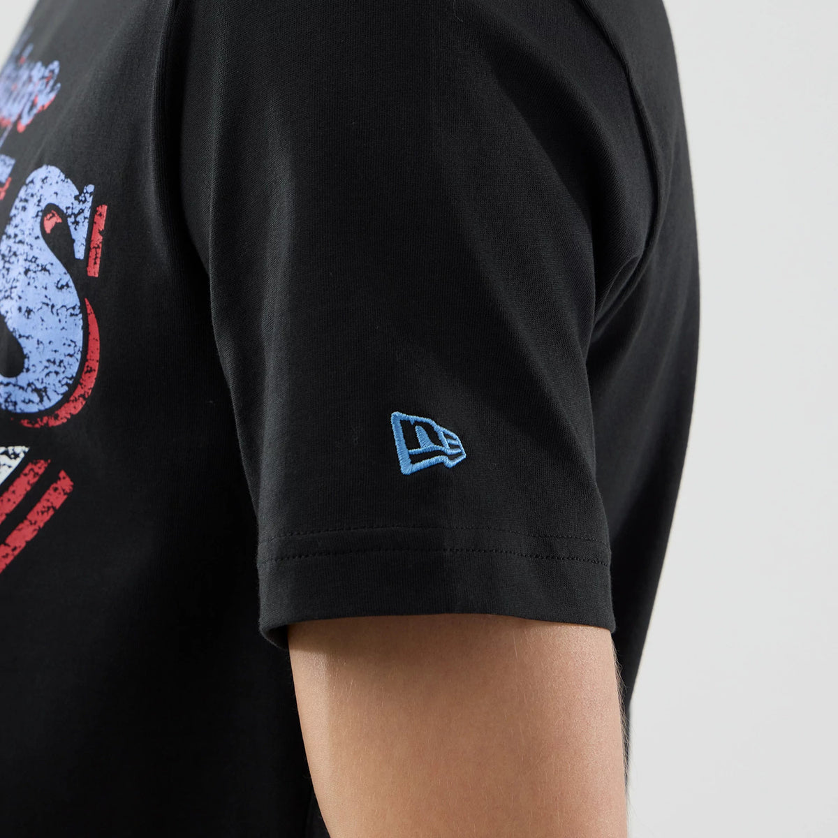 New Era Chicago Bulls NBA City Edition Black T-Shirt, side view showing a small blue embroidered New Era logo on the sleeve, with distressed red and blue graphics partially on the chest.