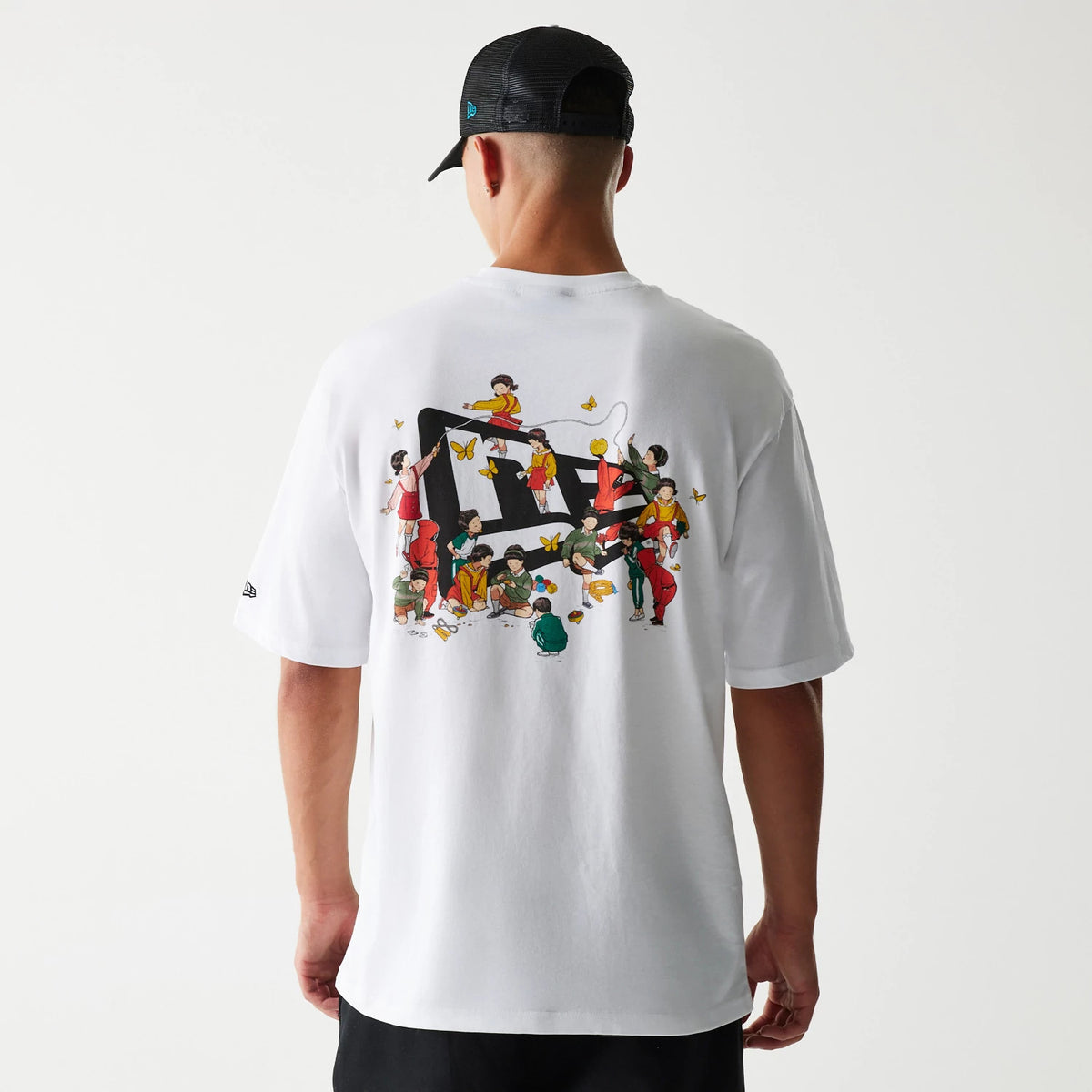 New Era Netflix Squid Game White Oversized T-Shirt, back view on a model wearing a black cap, featuring a colourful graphic of characters with butterflies centred on the white fabric and a small embroidered New Era logo on the sleeve.